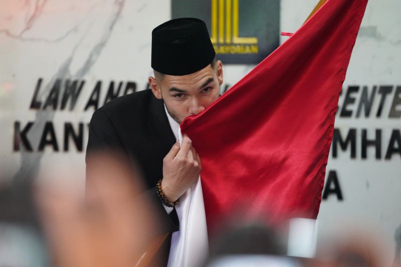 Pesepak bola Sandy Walsh mencium bendera merah putih seusai mengucapkan Sumpah dan Janji Setia Pewarganegaraan.