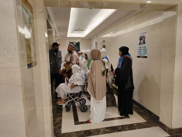 Jemaah lansia dan penyandang disabilitas bercampur dengan jemaah lainnya mengantre lift 