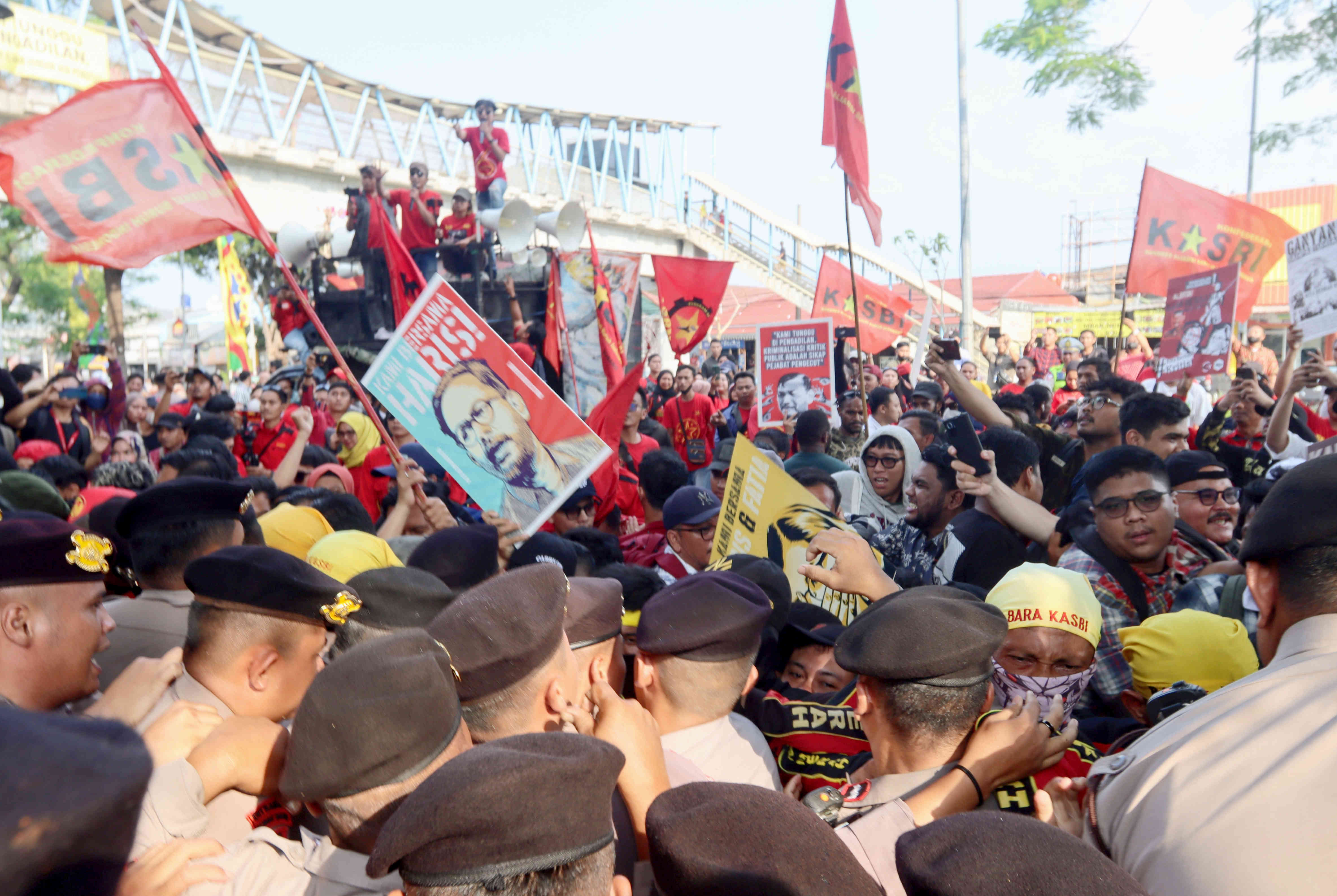 Petugas kepolisian terlibat aksi dorong-dorongan dengan masa pendukung Haris Azhar dan Fatia Maulidiyanti, usai sidang di PN Jakarta Timur