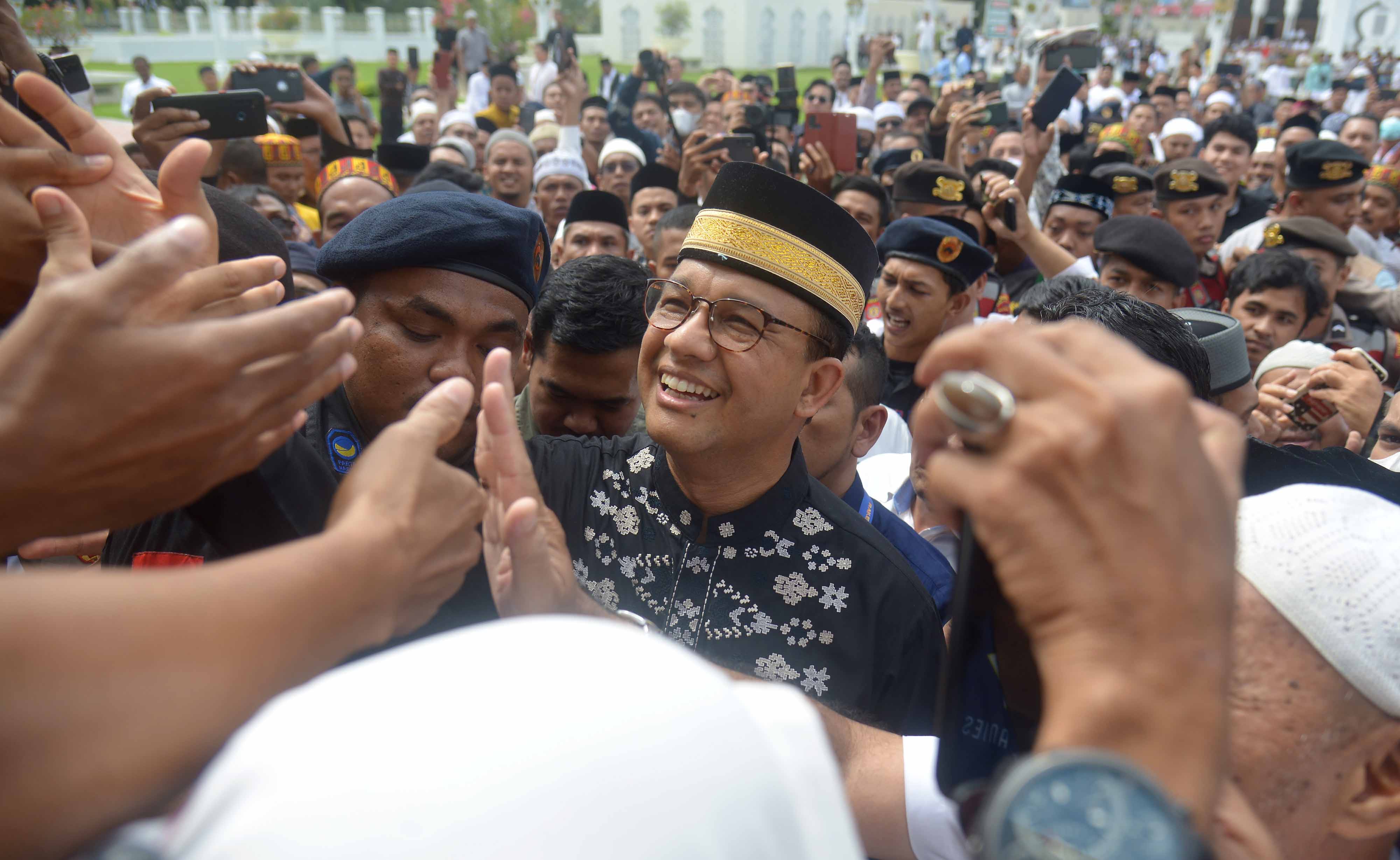 Bacapres Partai NasDem, Anies Baswaden (tengah) berjabat tangan dengan warga seusai melaksanakan shalat Jumat di Masjid Raya Baiturrahman