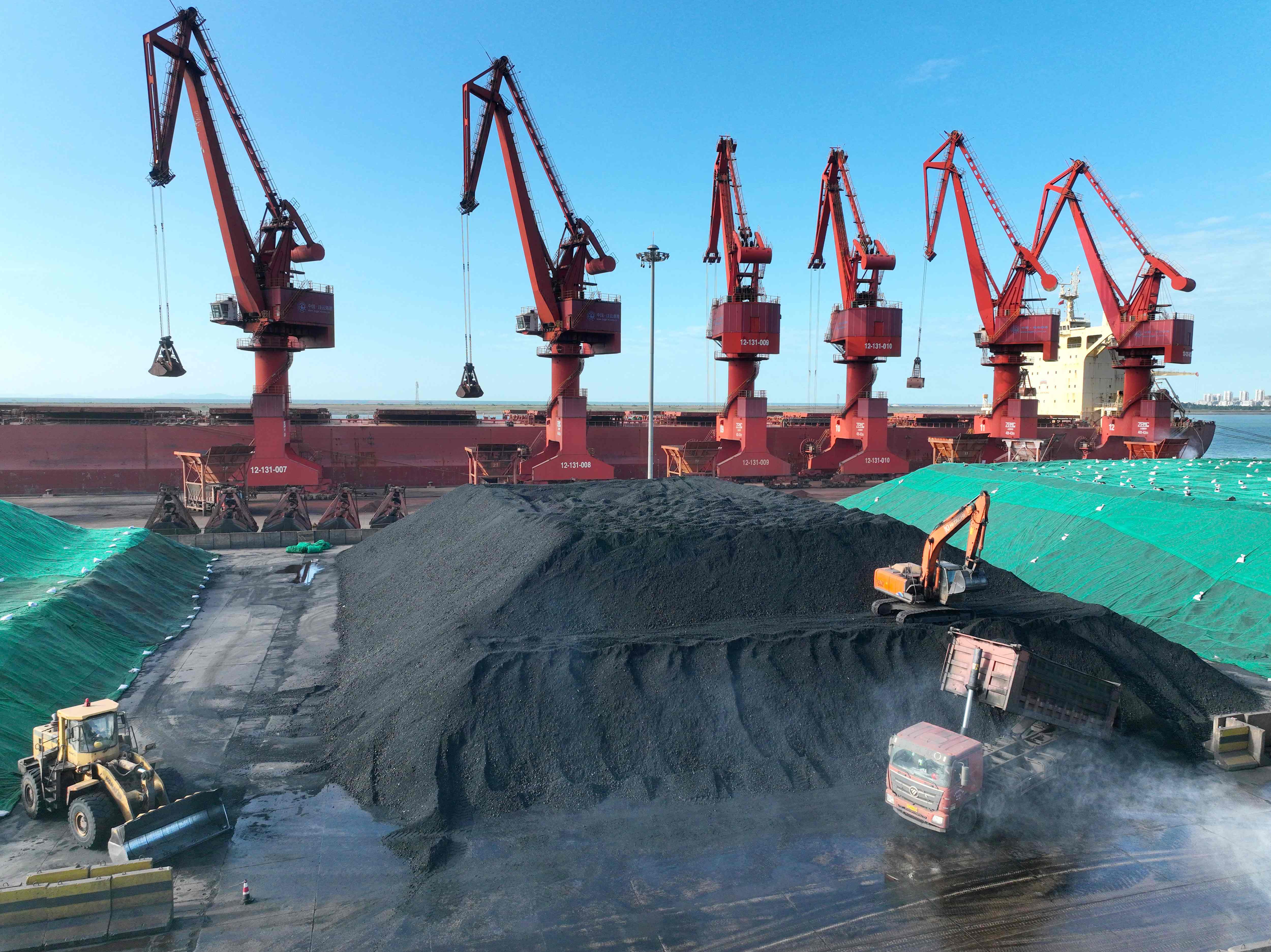 Alat excavator memindahkan batu bara di Pelabuhan Lianyungang, Jiangsu, Tiongkok.