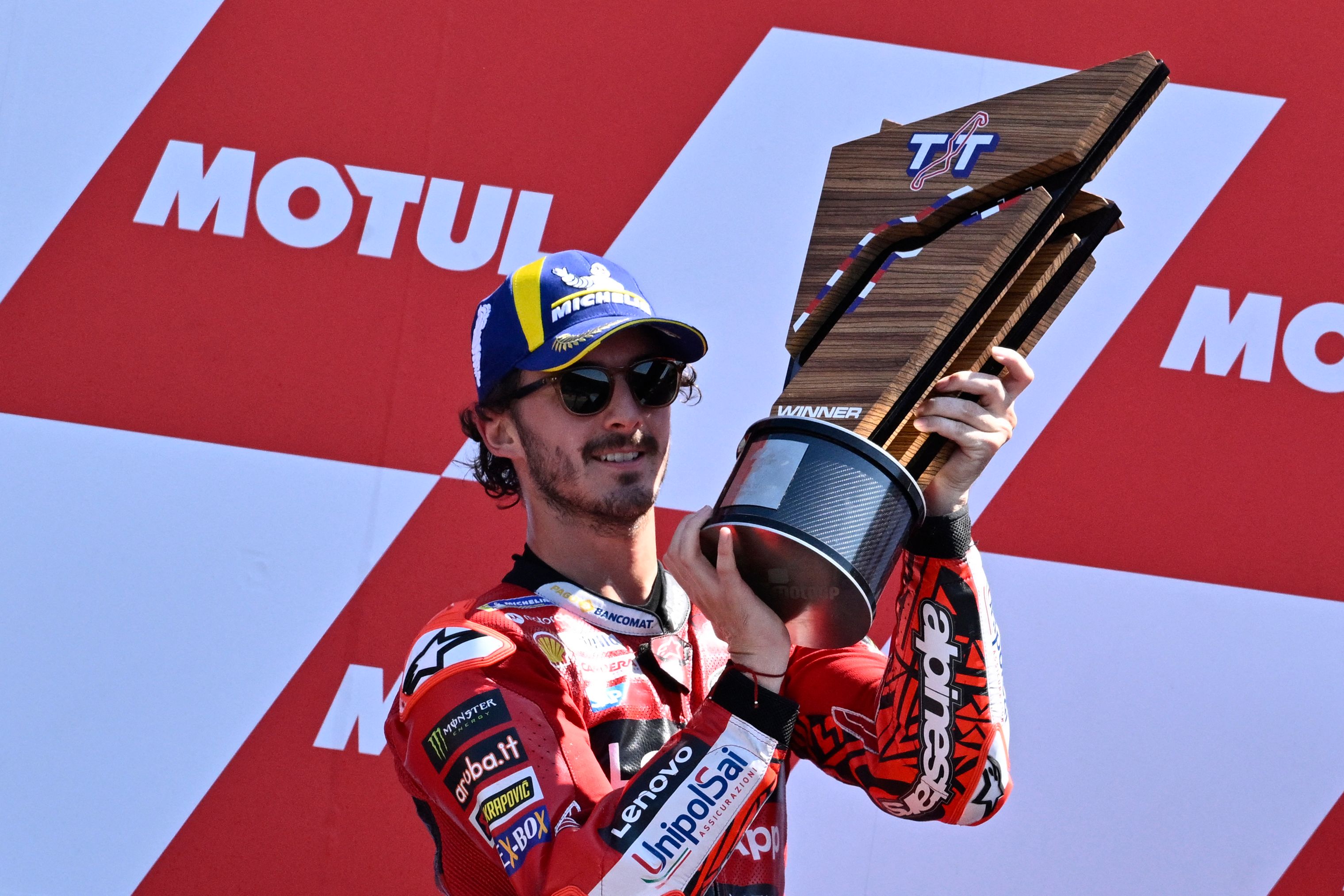 Pembalap Ducati Lenovo Francesco Bagnaia mengangkat trofi usai menjadi juara di GP Belanda.