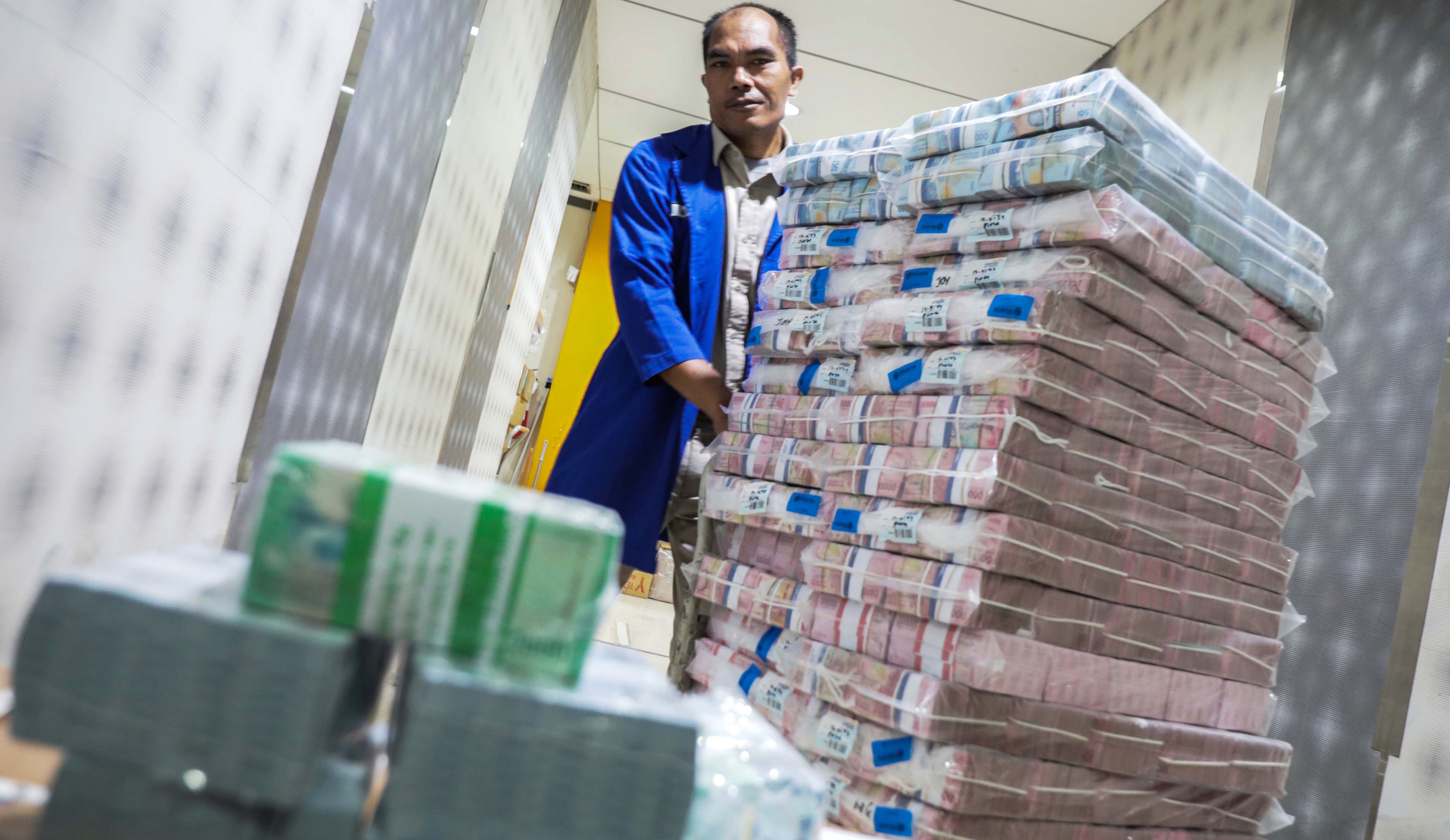 Petugas mengecek uang tunai sebelum  didistribusikan ke ATM