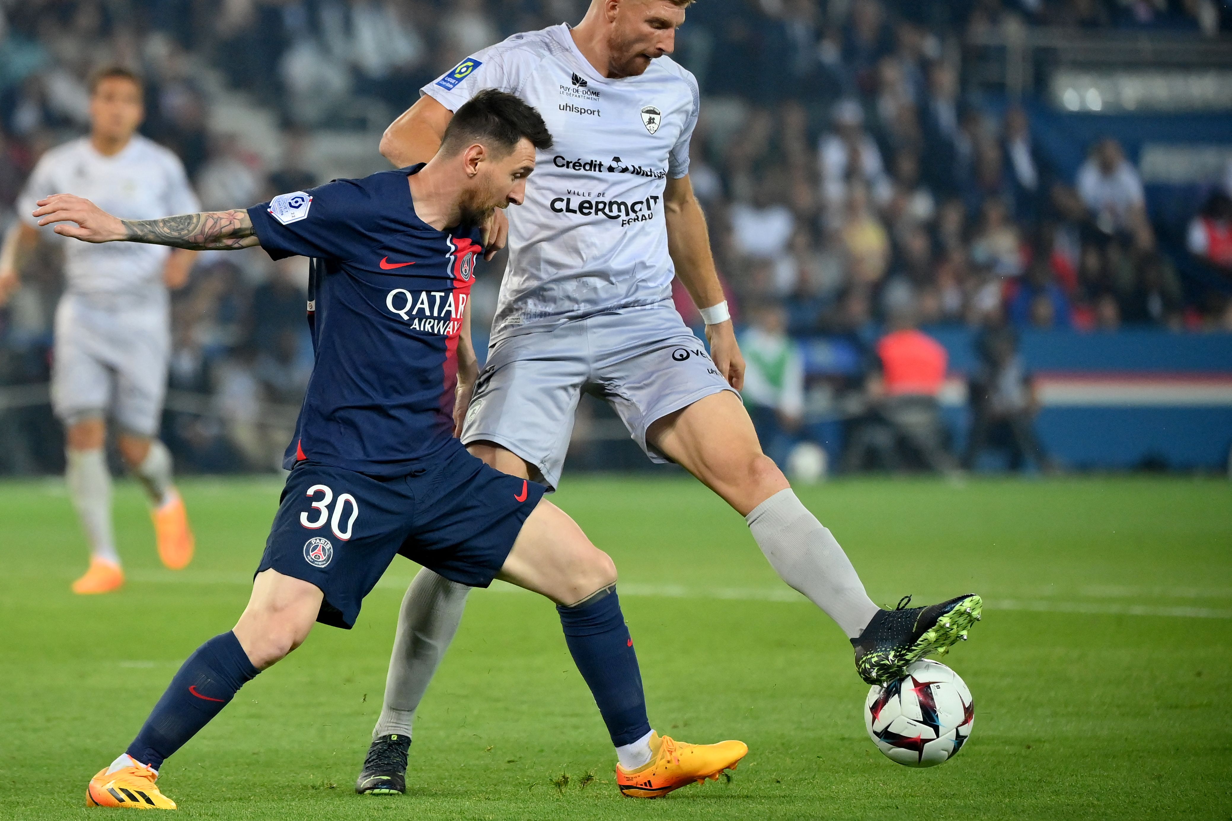 Penyerang PSG Lionel Messi berduel dengan bek Clermont Maximiliano Caufriez di laga Ligue 1.