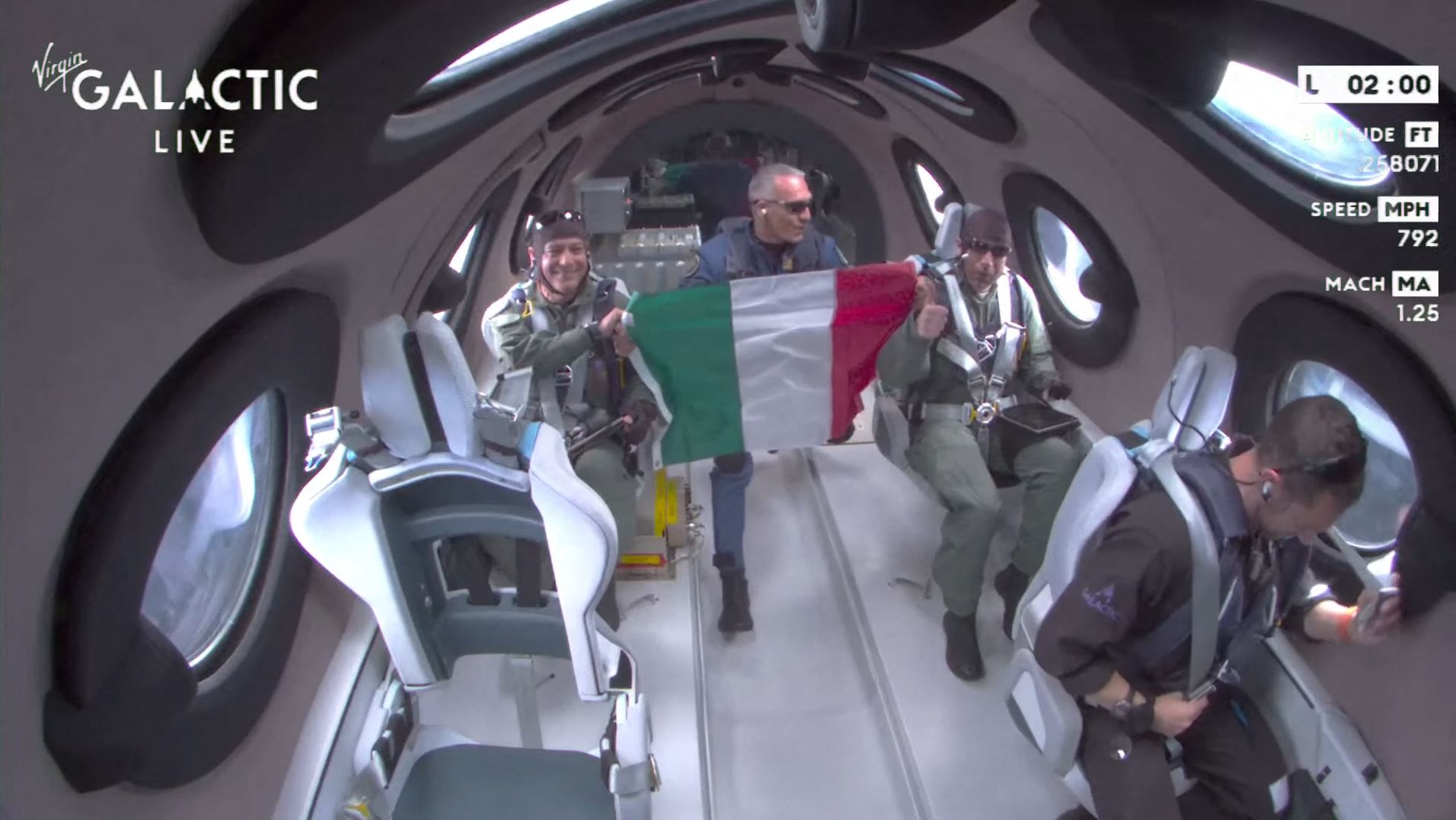 Penumpang penerbangan Virgin Galactic yang merupakan perwira Angkatan Udara Italia mengibarkan bendera.
