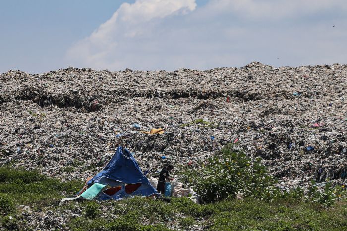 Seorang pemulung mencari barang di tumpukan sampah yang menggunung di TPA Cipayung, Depok, Jawa Barat, Jumat (6/1).