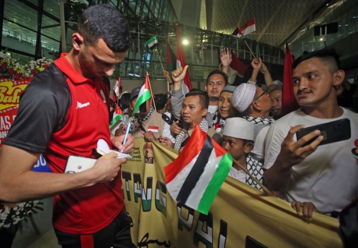 Pesepak bola Timnas Palestina Taufik Ali memberikan tandatangan untuk pendukungnya di Terminal 3 Bandara Soekarno Hatta, Tangerang.