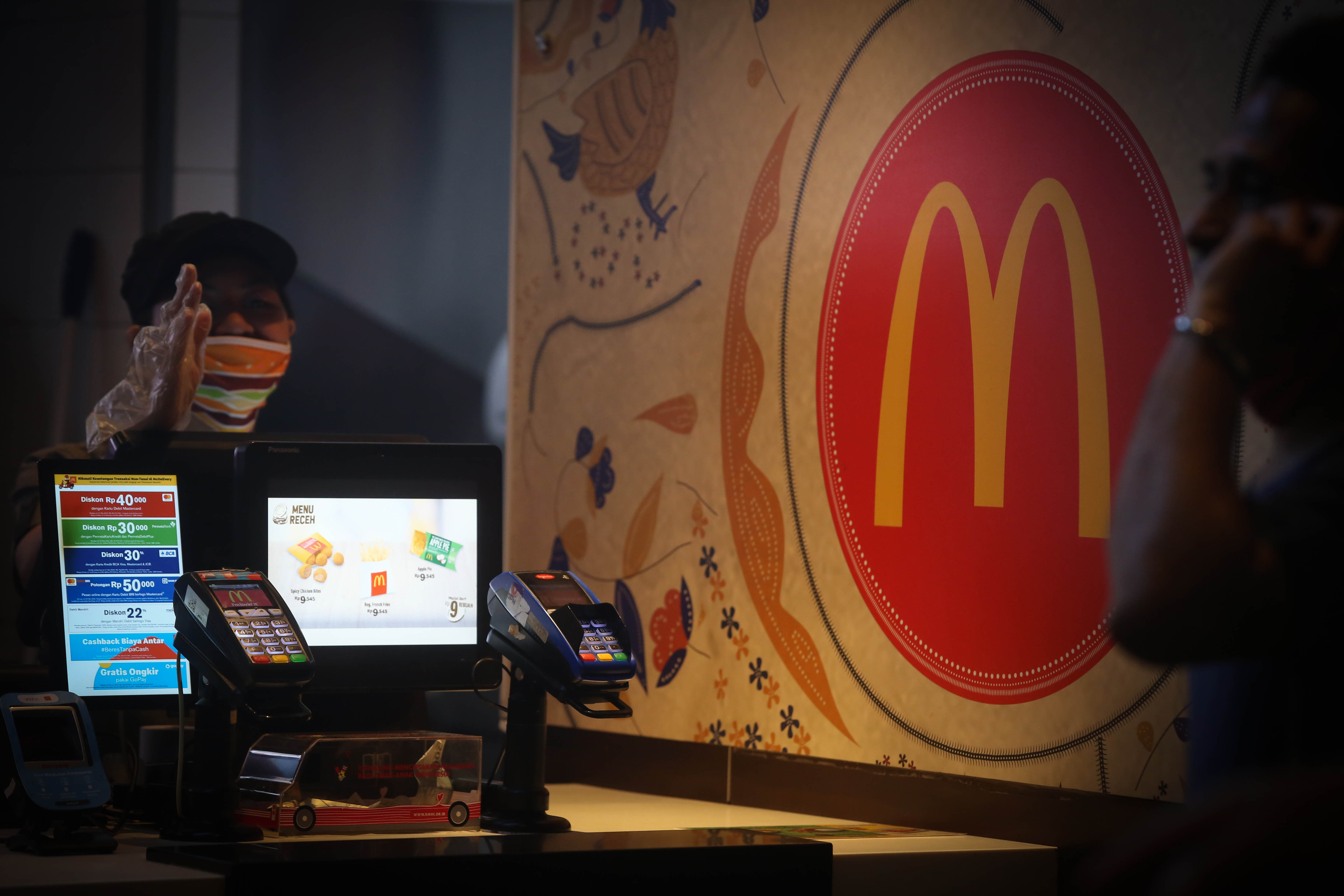 Pegawai melayani pesanan makanan siap saji di McDonald's 