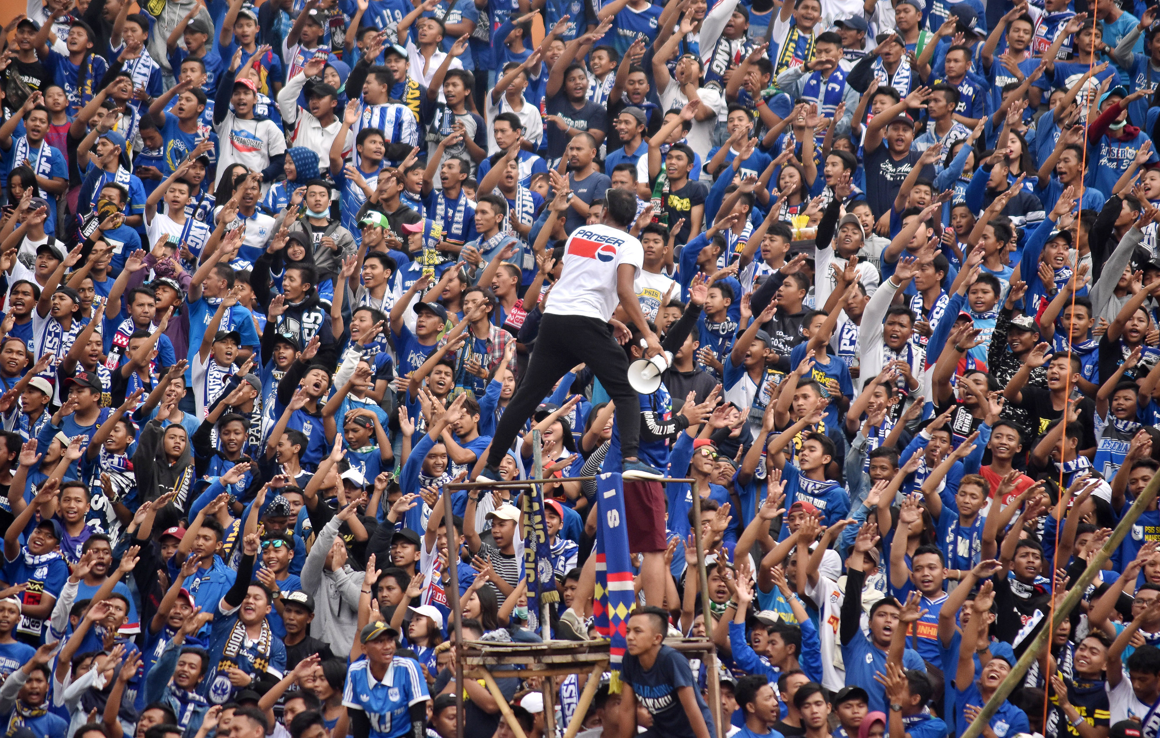 Suporter klub PSIS Semarang yang tergabung dalam Panser Biru melakukan aksi koreografi saat mendukung PSIS melawan Arema FC Malang.