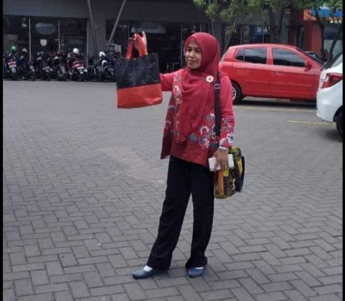 Pengguna memakai tas hasil daur ulang sampah plastik