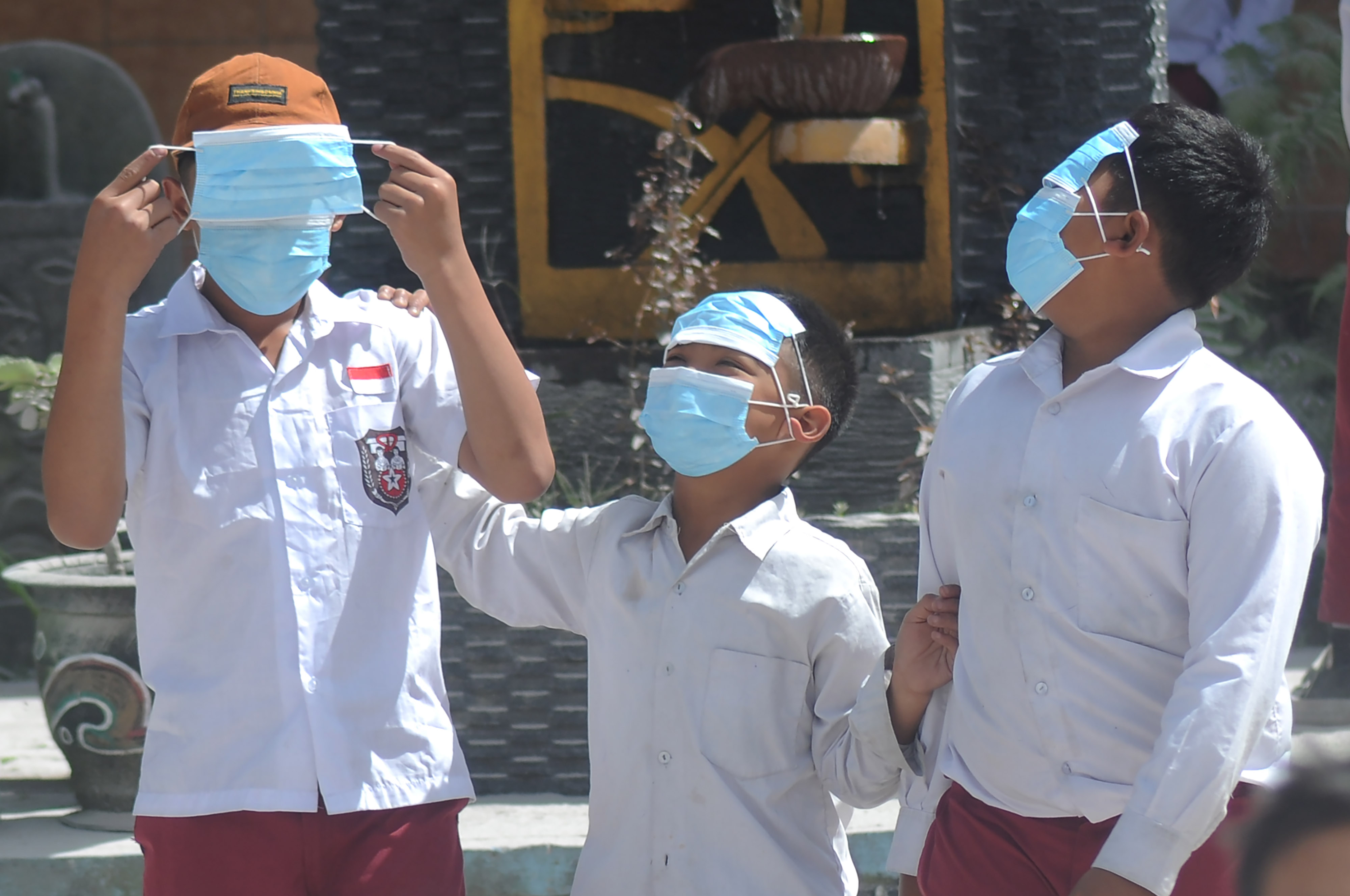 Sejumlah siswa menggunakan masker saat bermain di halaman sekolah saat jam istirahat 