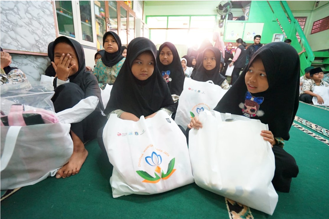 Anak-anak panti asuhan menerima bingkisan saat bakti sosial Dharma Wanita Sarana Jaya 