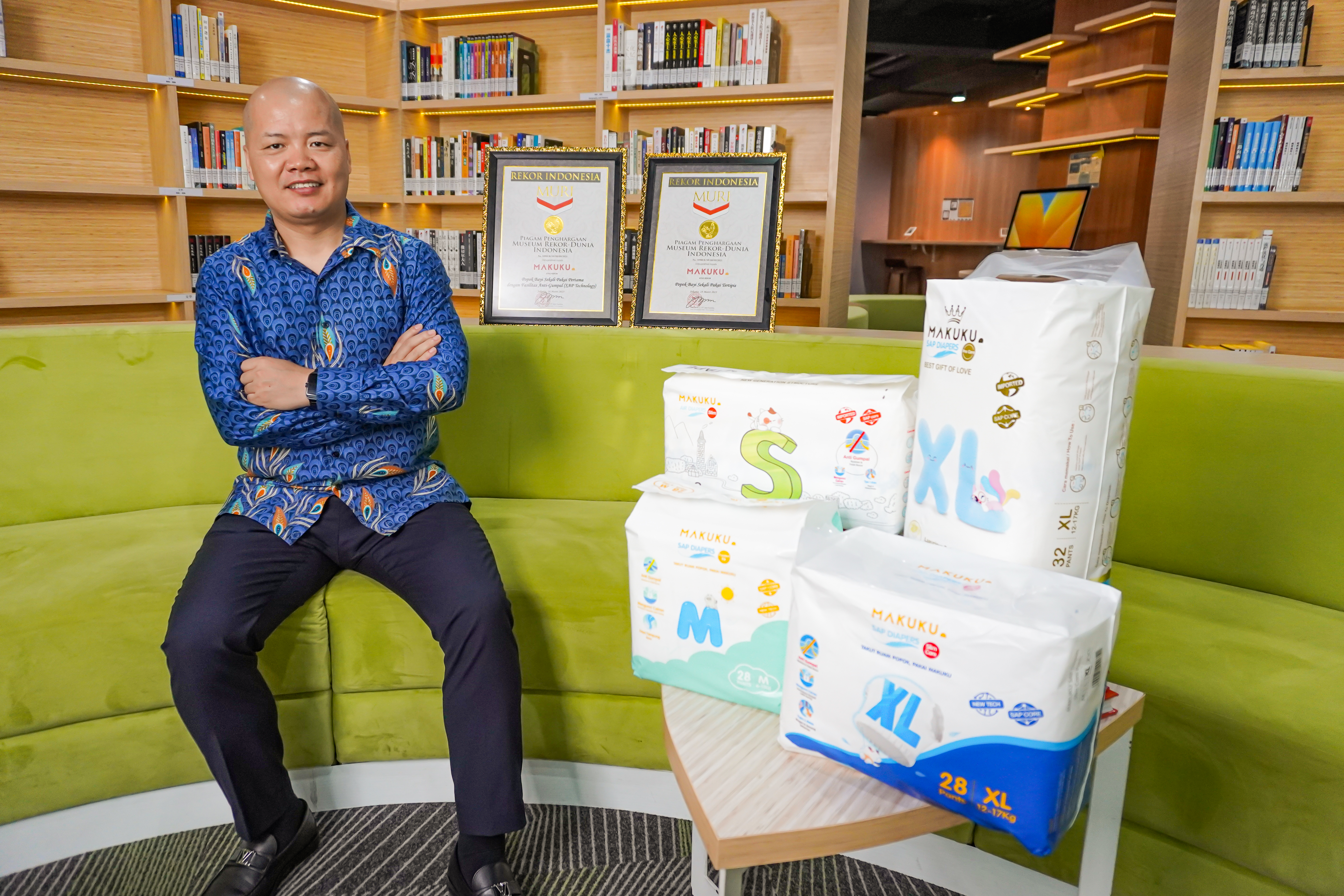 CEO Makuku, Jason Lee, dengan produk popoknya dan dua piagam Rekor MURI.