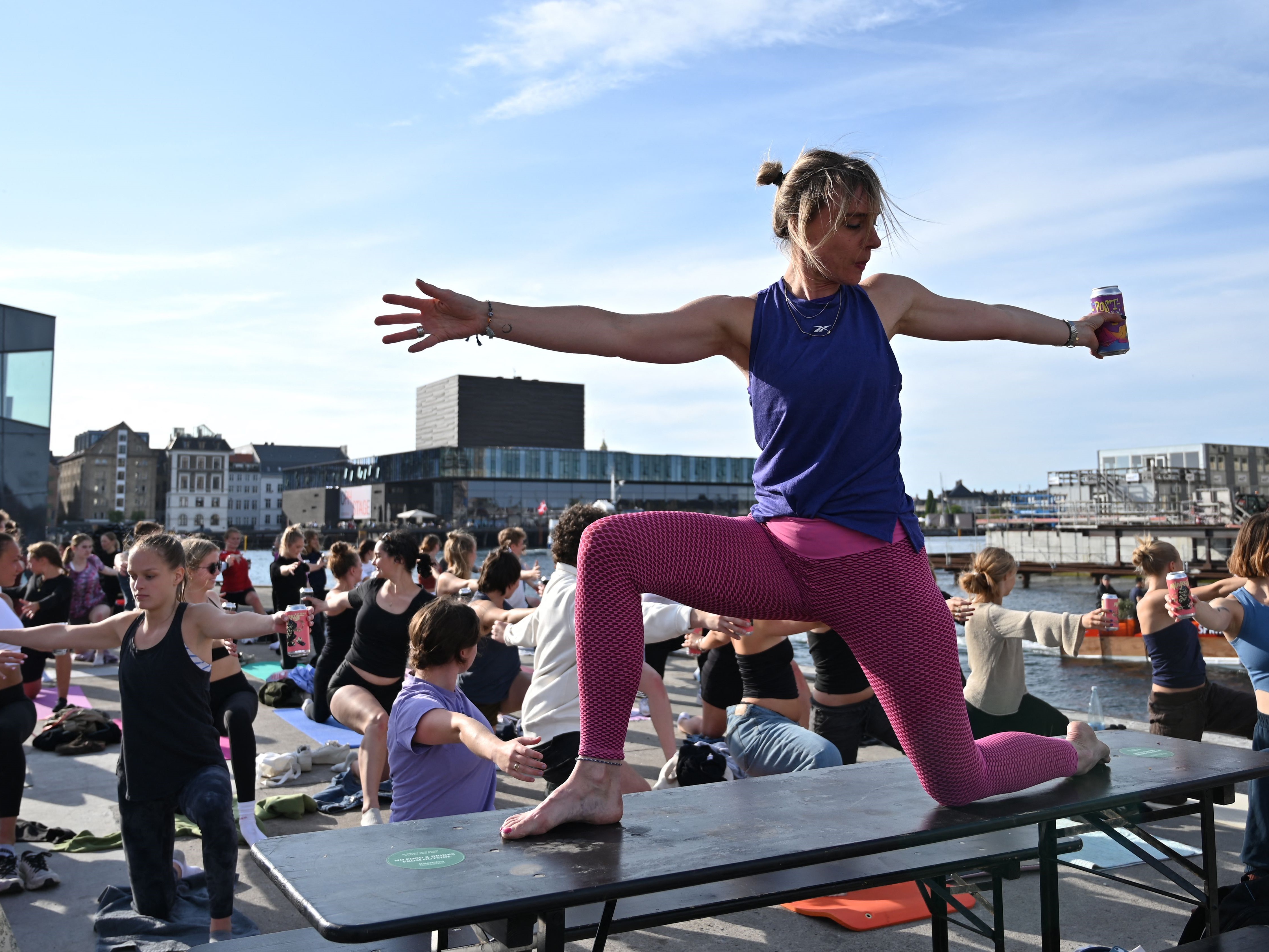 Instruktur yoga Anne Lund memegang sekaleng bir selama apa yang disebut 'acara Yoga Bir' di Kopenhagen, pada 31 Mei 2023.