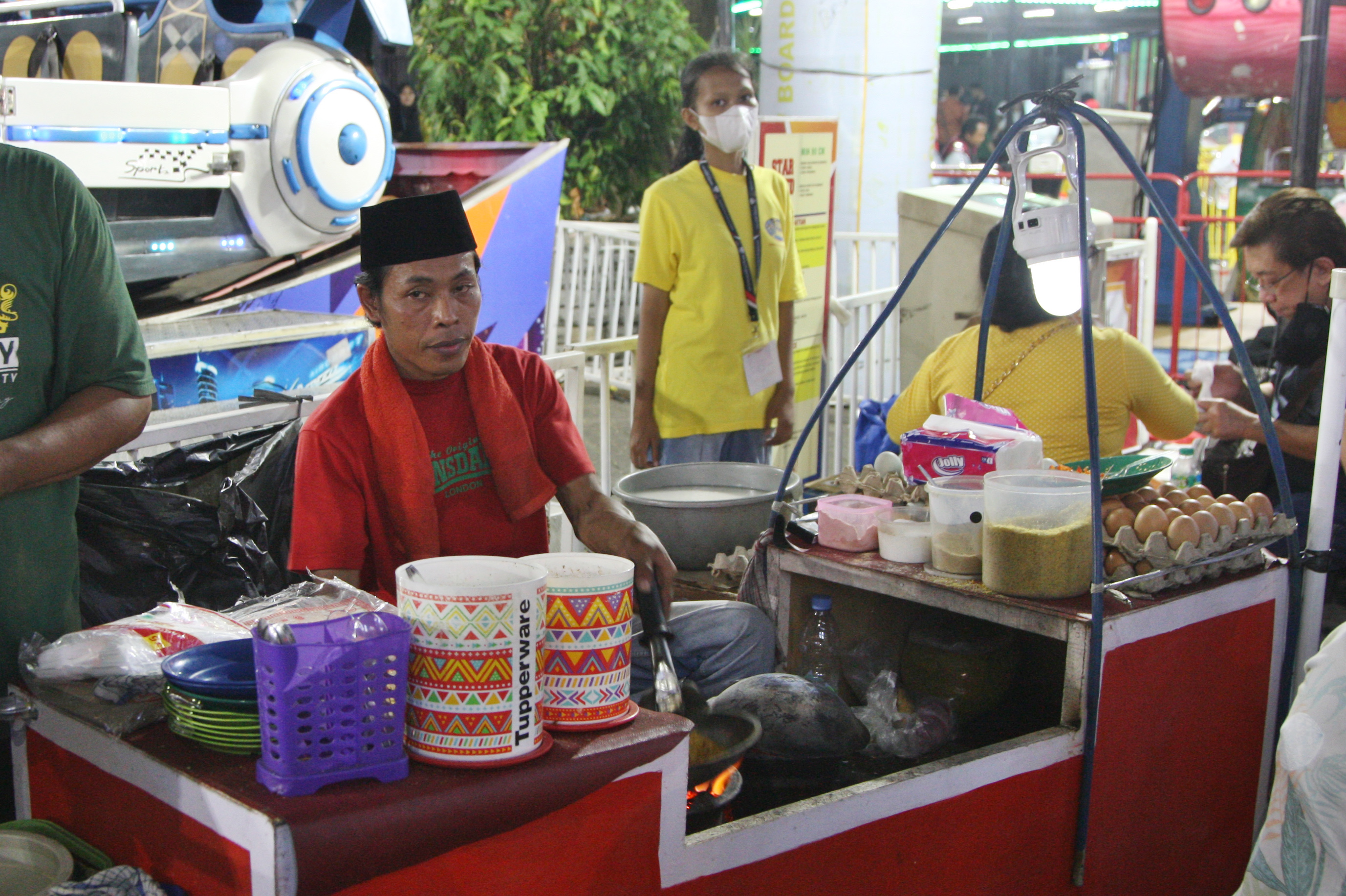  Pedagang kerak telor tengah membuat pesanan pembeli di arena Jakarta Fair Kemayoran (JFK) 