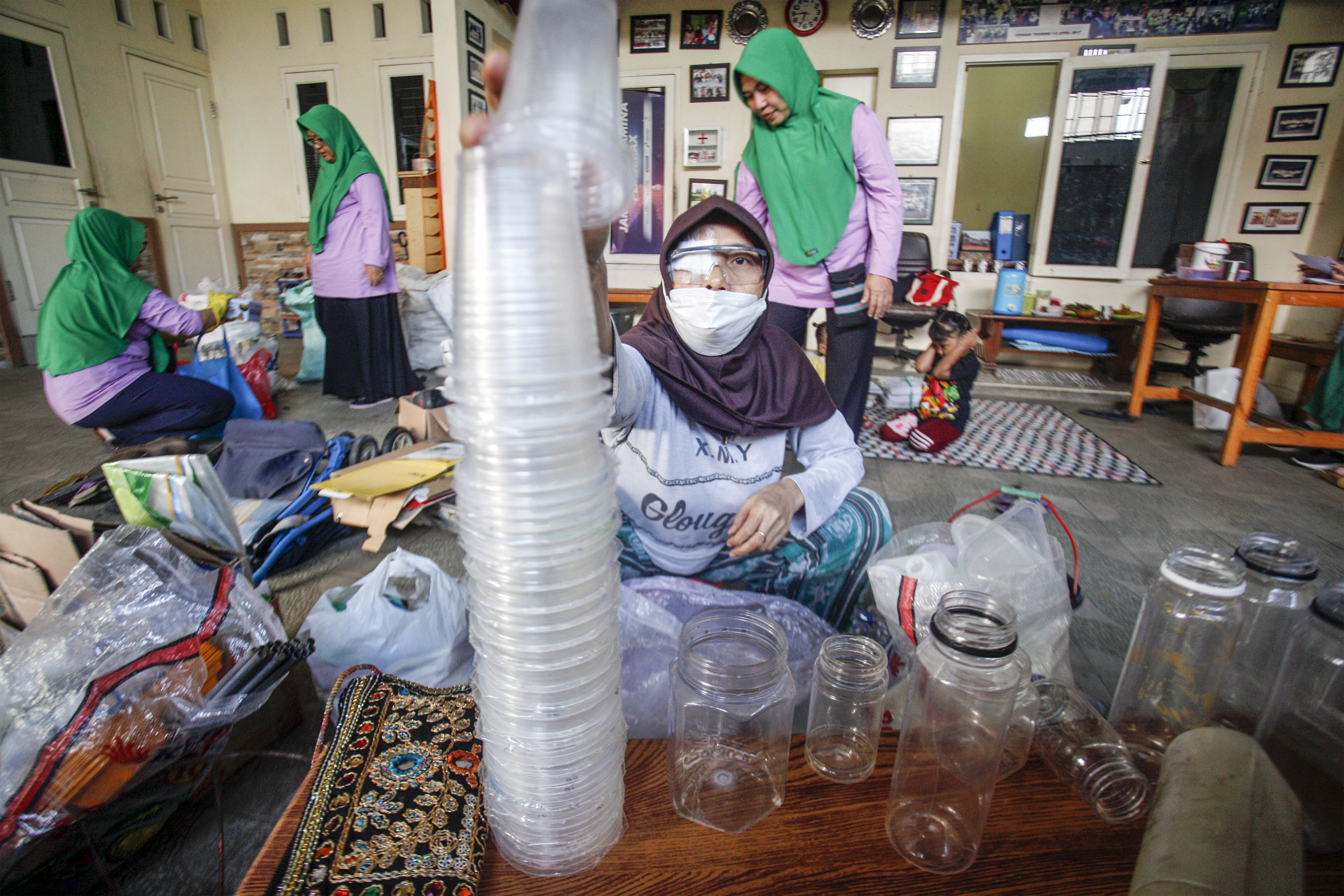 Warga bersama petugas bank sampah Bougenville memilah sampah di Komplek Perumahan Deppen, Pemancar, Kota Depok, Jawa Barat 