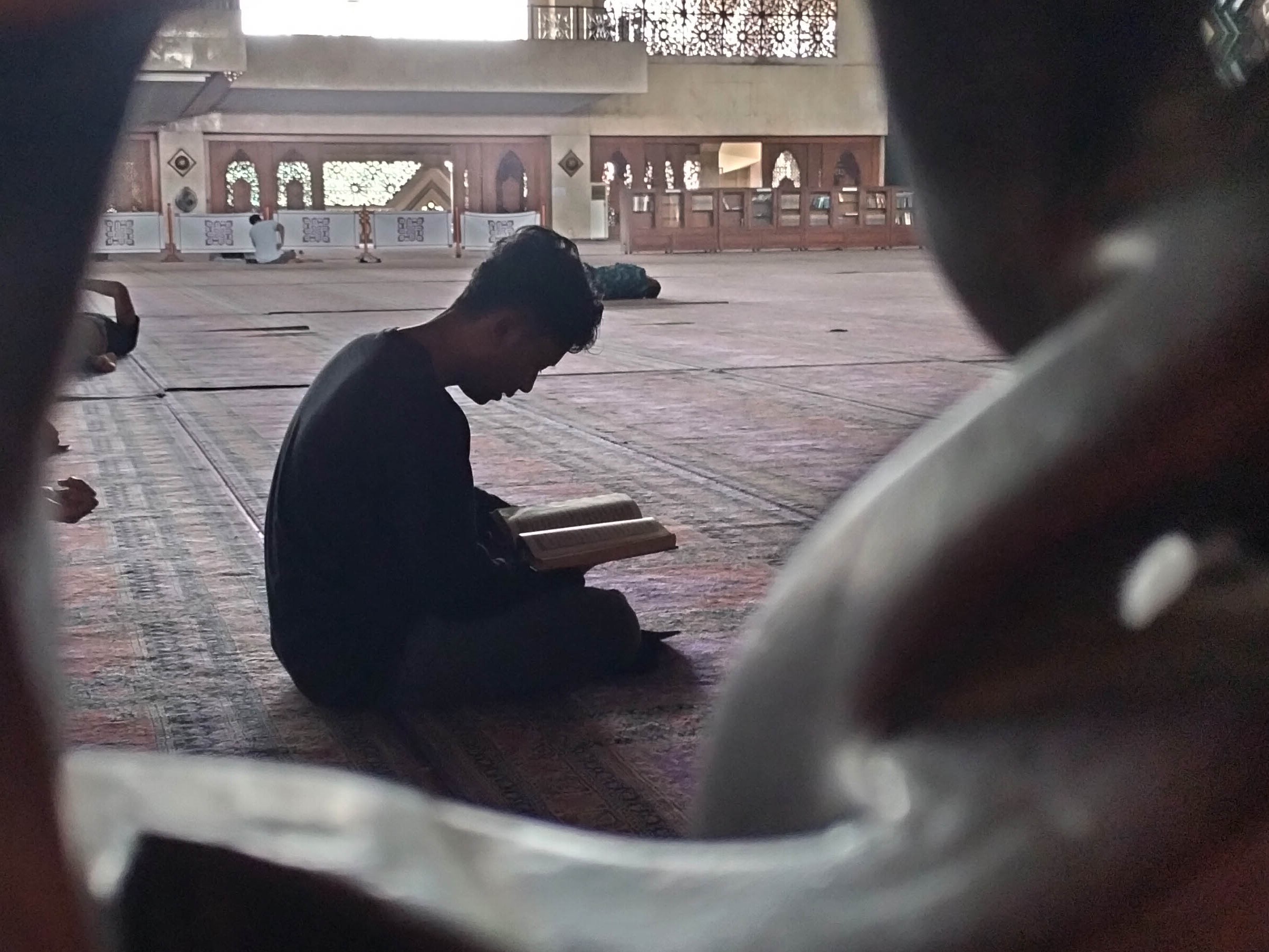 Umat Islam membaca Al-Qur'an setelah melaksanakan salat zuhur di Masjid At-Tin, Jakarta Timur.