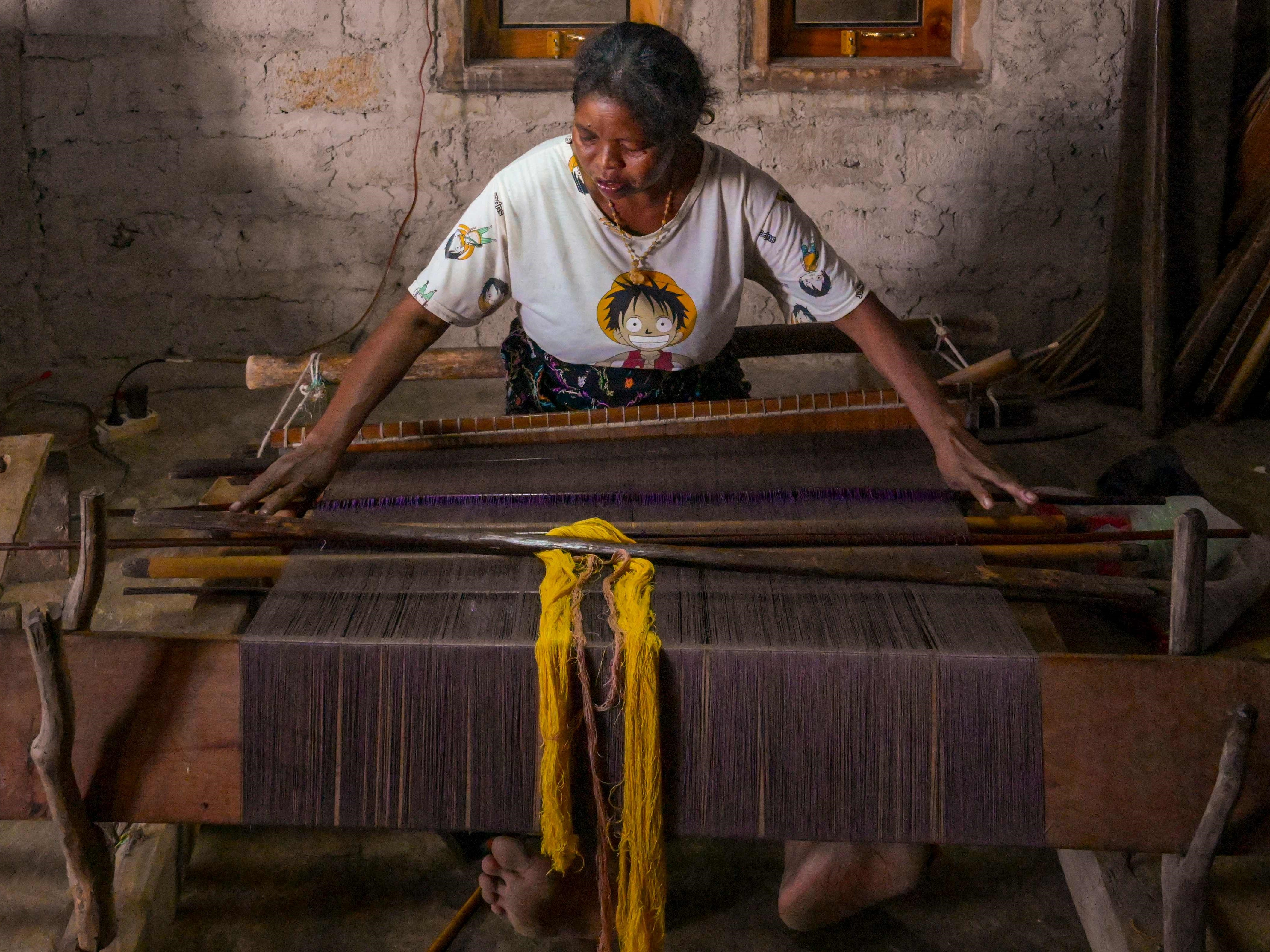 Yovita Jelumut menenun senar yang diwarnai secara alami dengan pewarna dari hutan dan kebun, Desa Ponto Ara, Manggarai Barat.