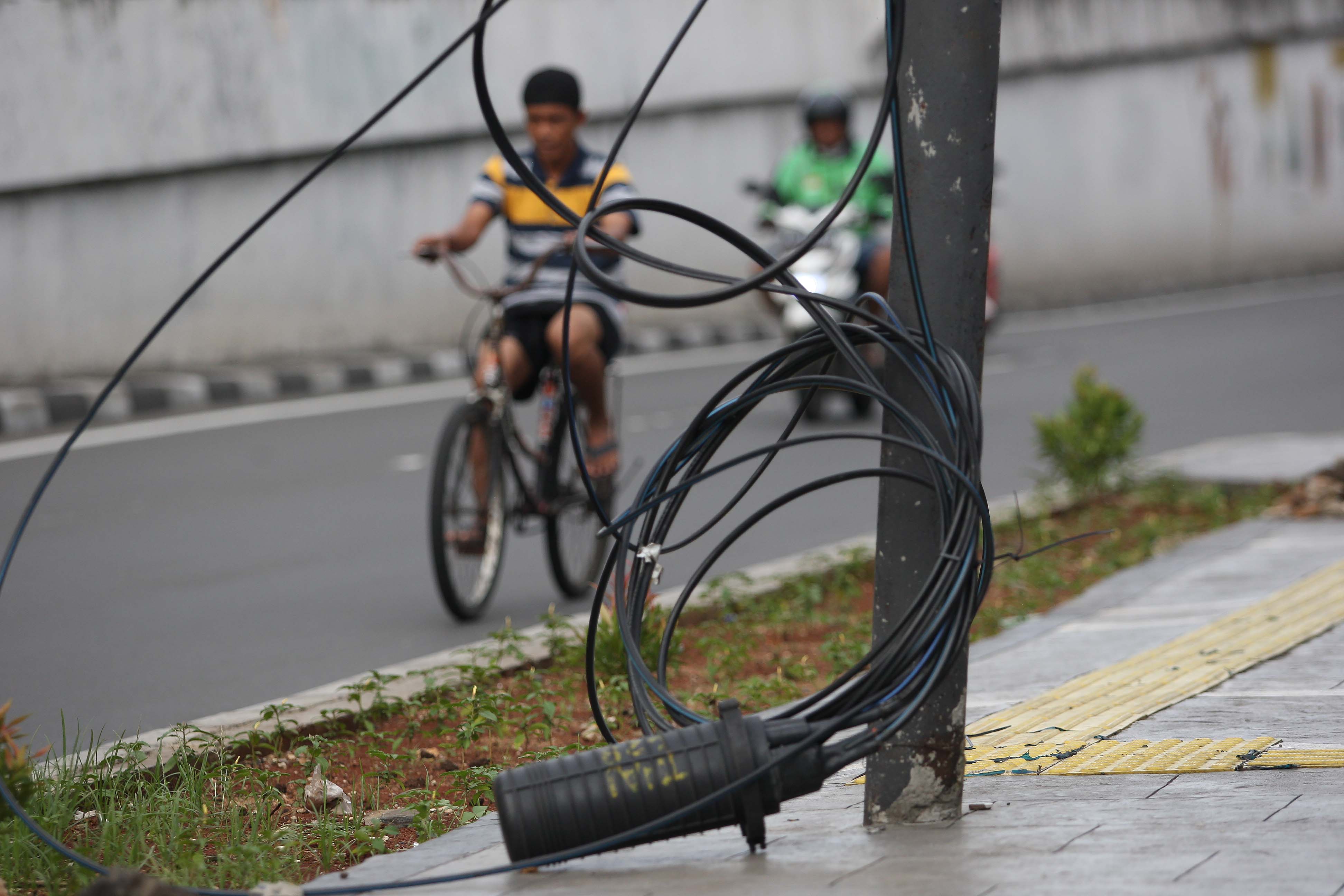 kabel utilitas yang menjuntai dan membahayakn pengguna jalan