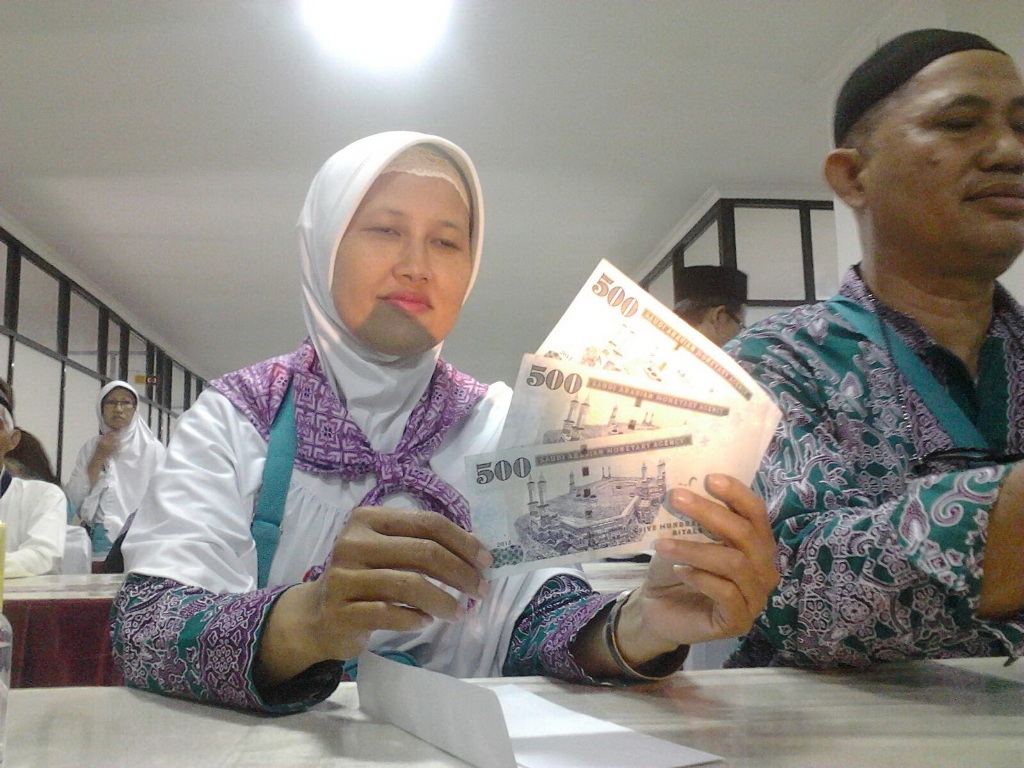 Jemaah haji menukarkan uang Riyal untuk living cost selama beribadah haji.