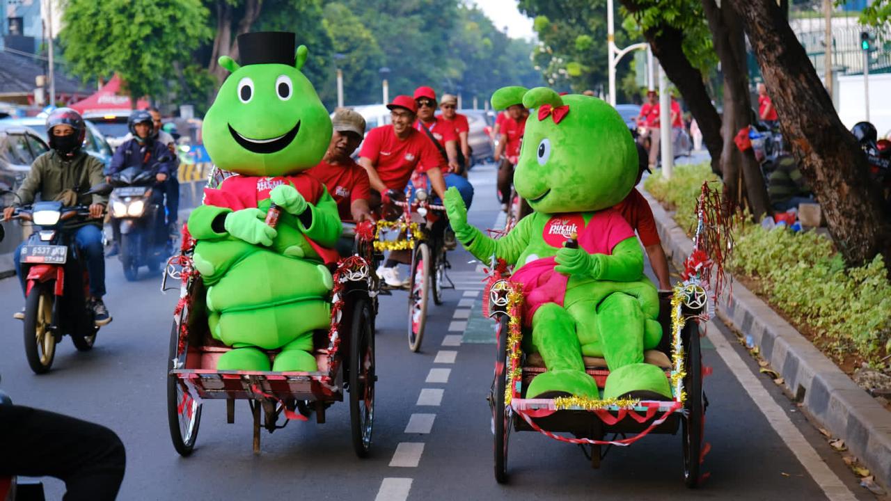 Maskot Teh Pucuk Harum menaiki becak untuk mempromosikan Festival Kuliner Pucuk 'FavorHits Tiap Generasi' di Gedung Sarinah, Jakarta.