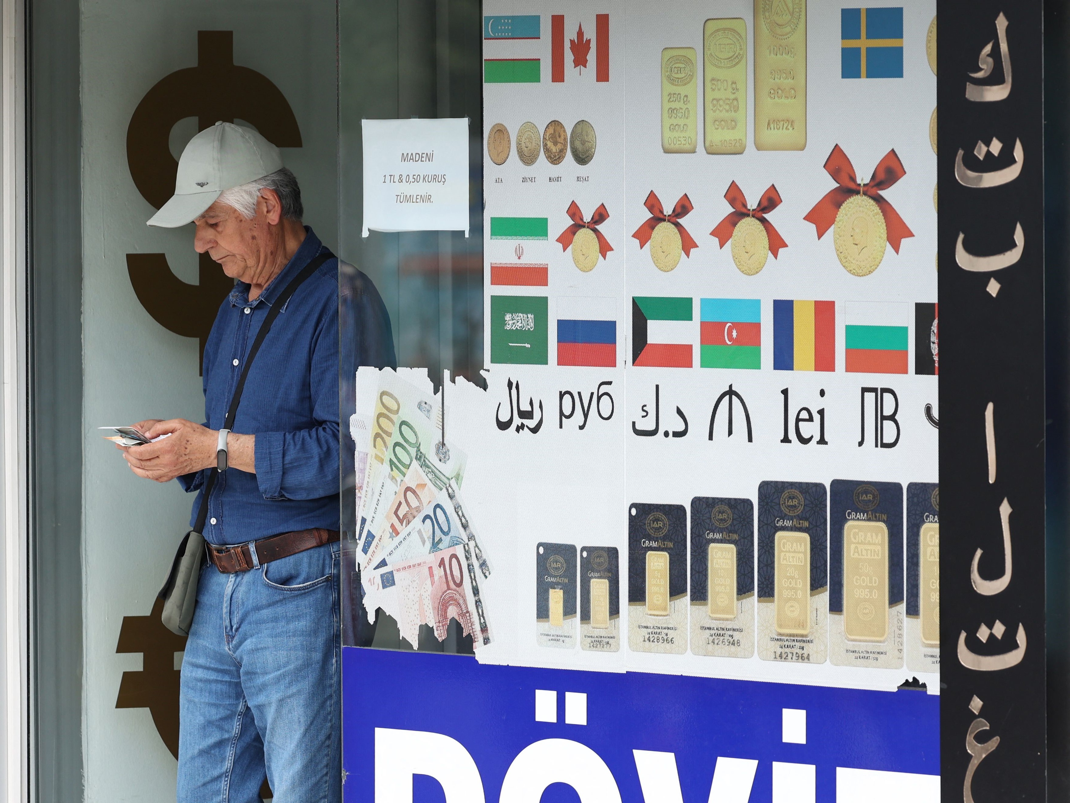 Seorang pria menghitung uang kertasnya saat meninggalkan penukaran mata uang di Ankara, Turki, pada 9 Juni 2023.