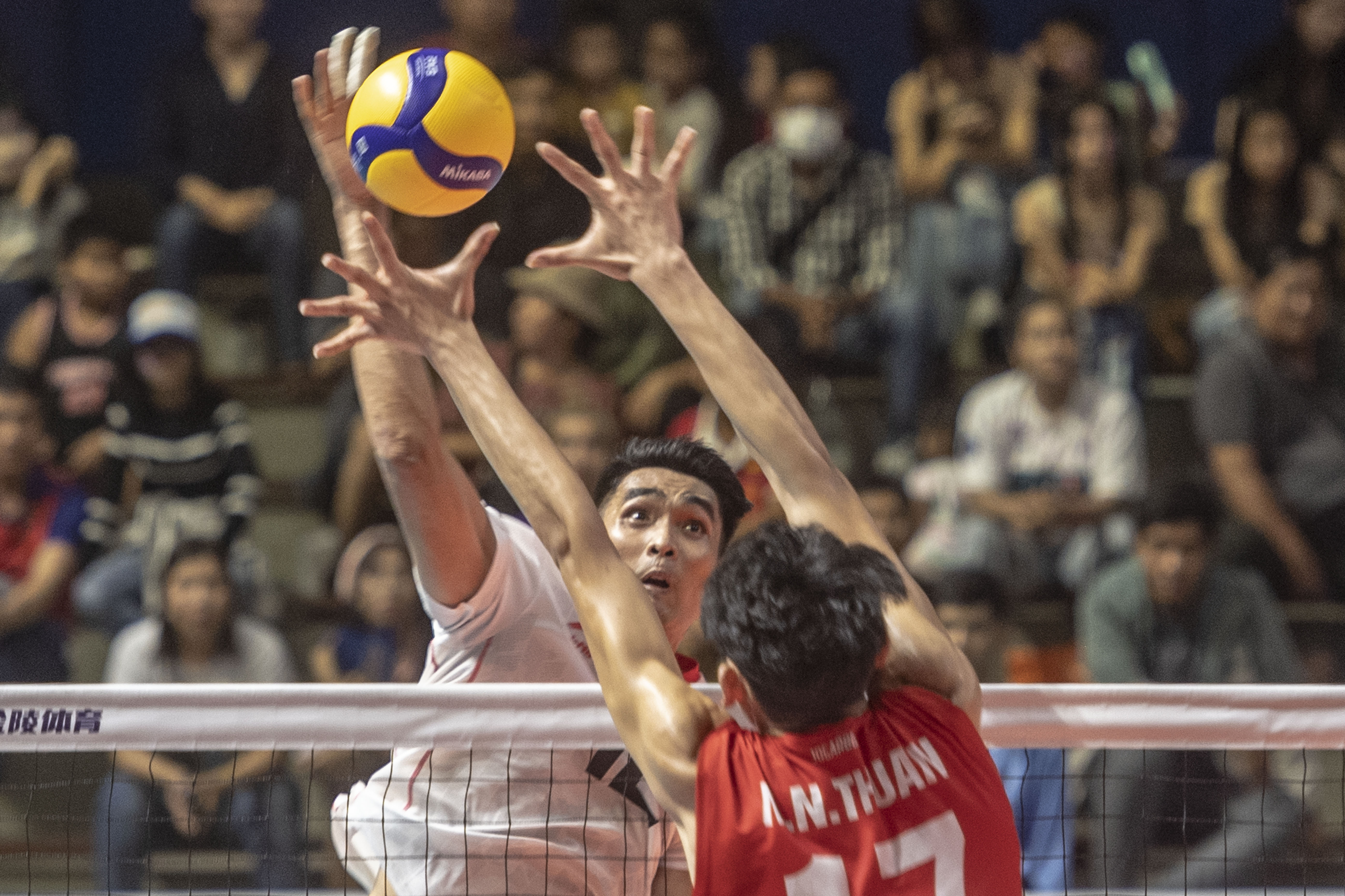 Pevoli putra Indonesia Nurmulki Rivan (kiri) melakukan smes ke arah Timnas Voli putra Vietnam Nguyen Ngoc Thuan (kanan).