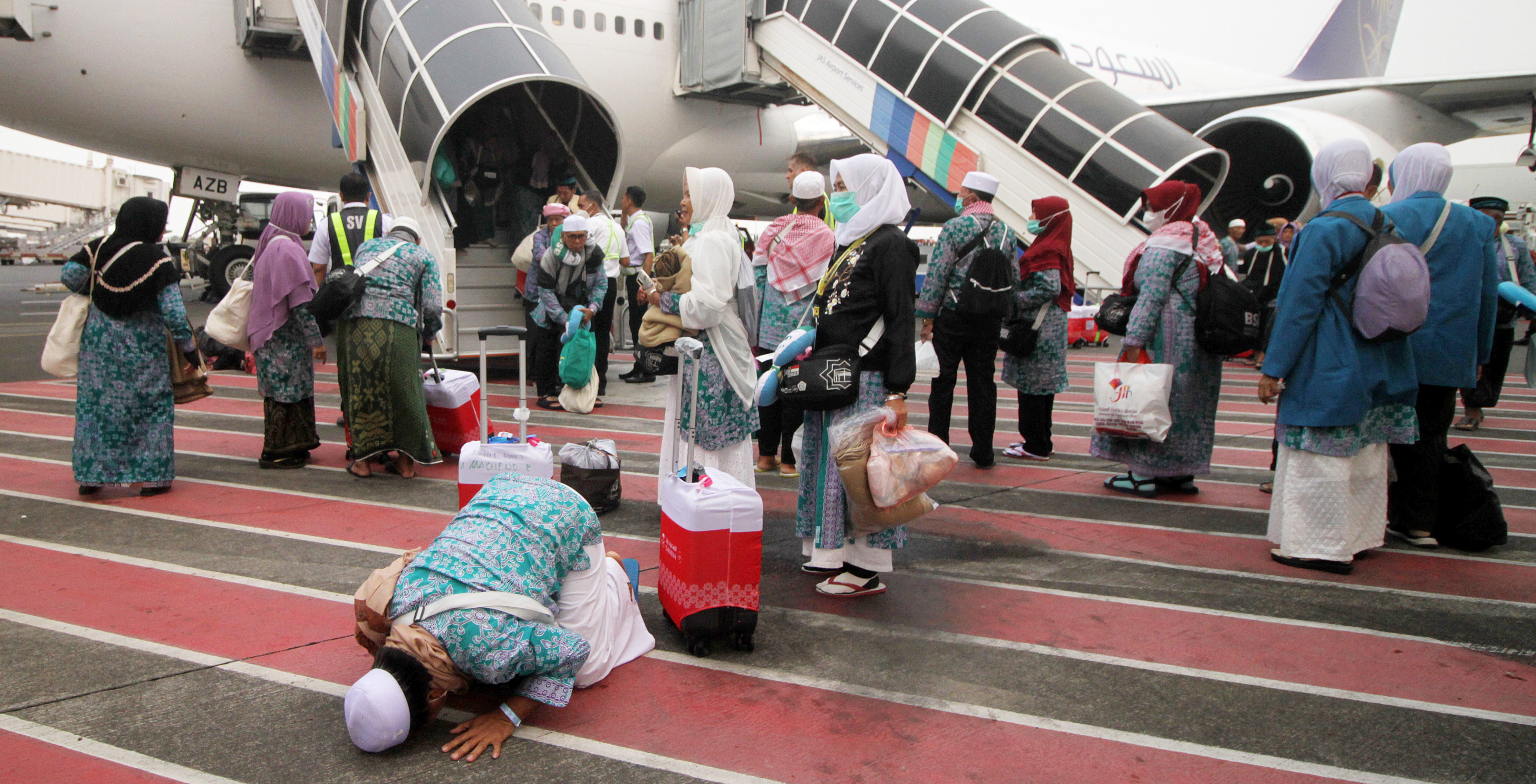 Jamaah haji melakukan sujud syukur saat tiba di Bandara Internasional Juanda Surabaya di Sidoarjo, Jawa Timur.