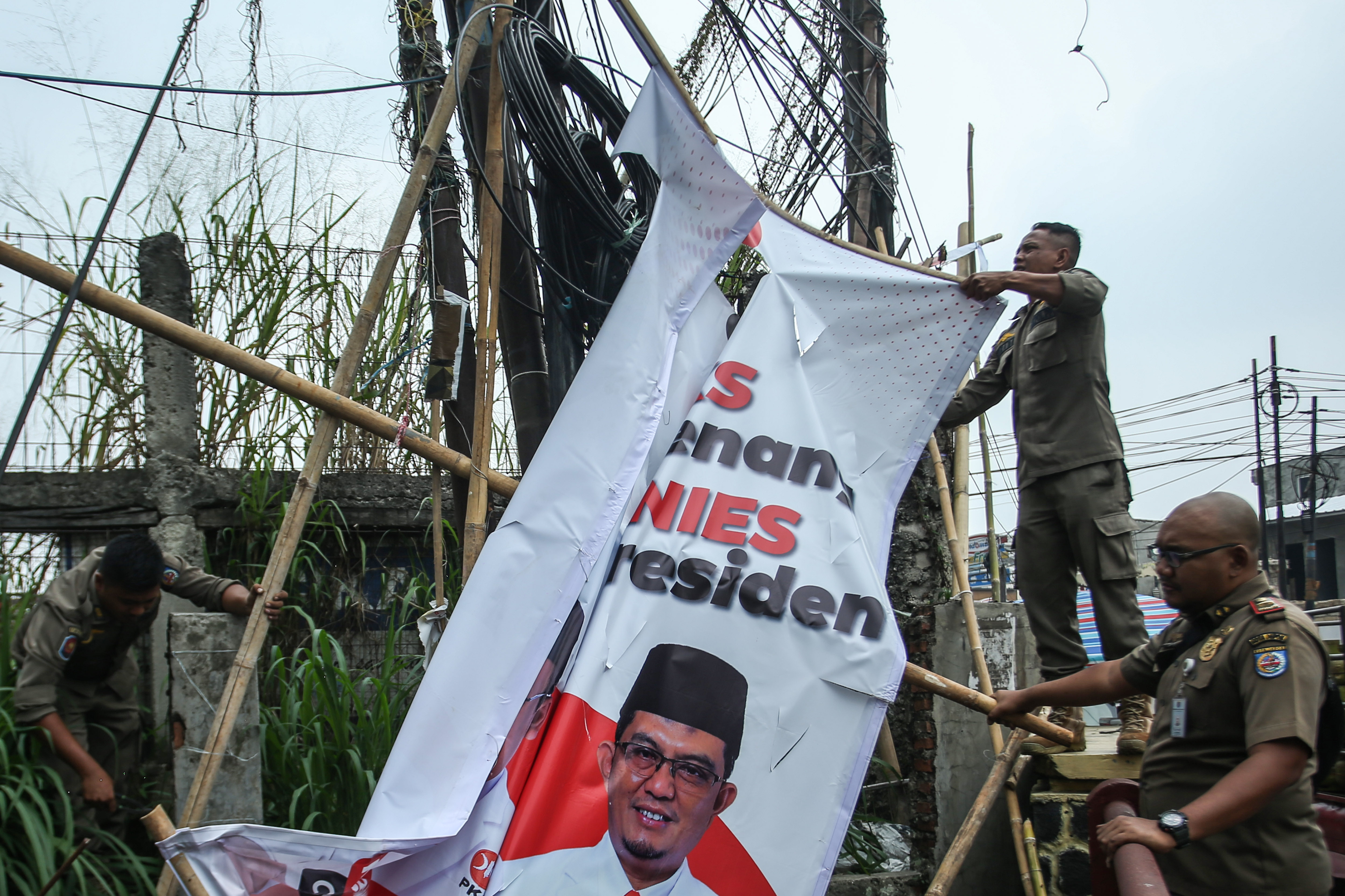 Petugas Satpol PP menertibkan atribut partai di Depok, Jawa Barat