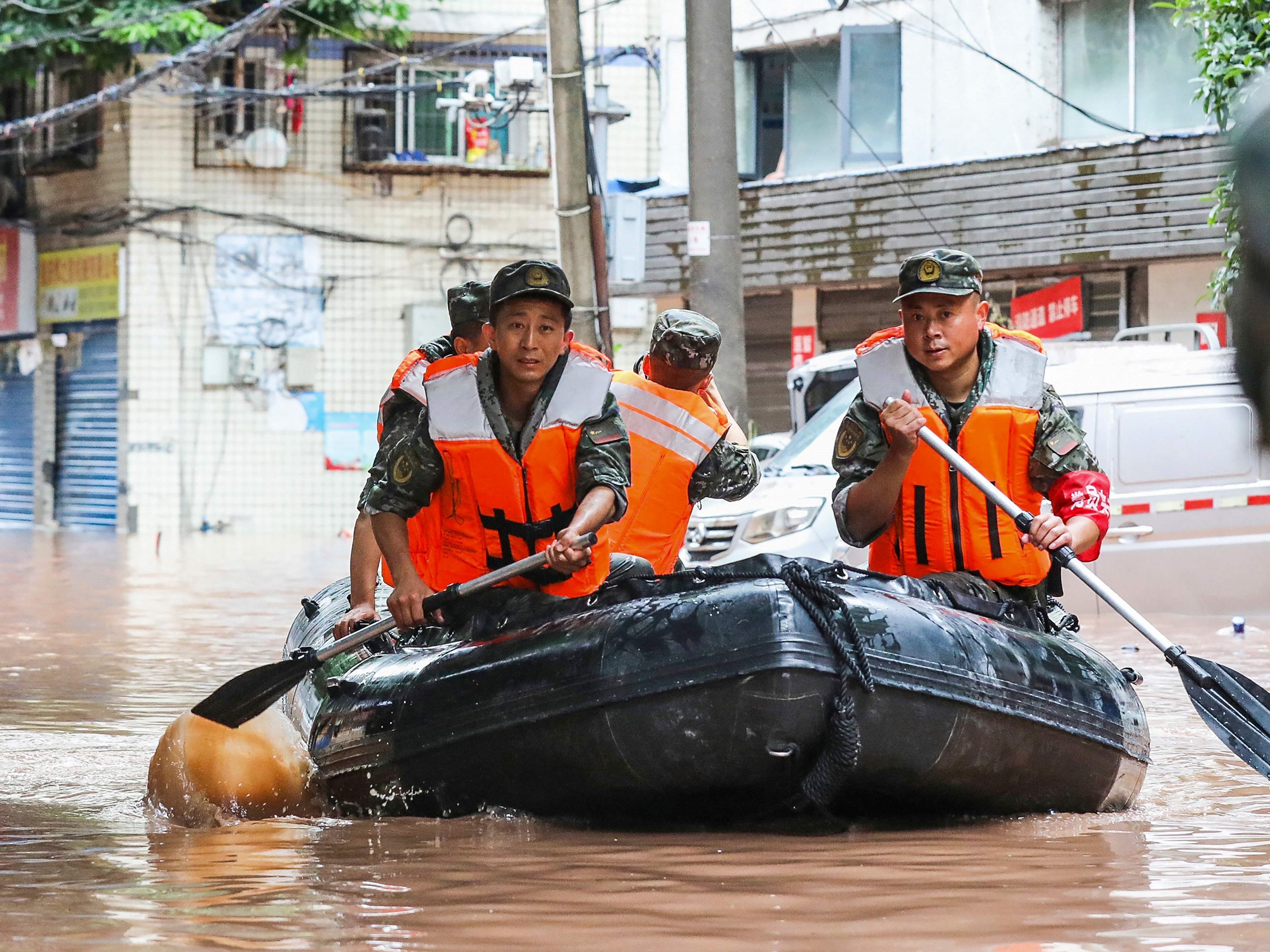 Polisi paramiliter menggeledah daerah yang dilanda banjir akibat hujan lebat di Chongqing barat daya China pada 4 Juli 2023.\