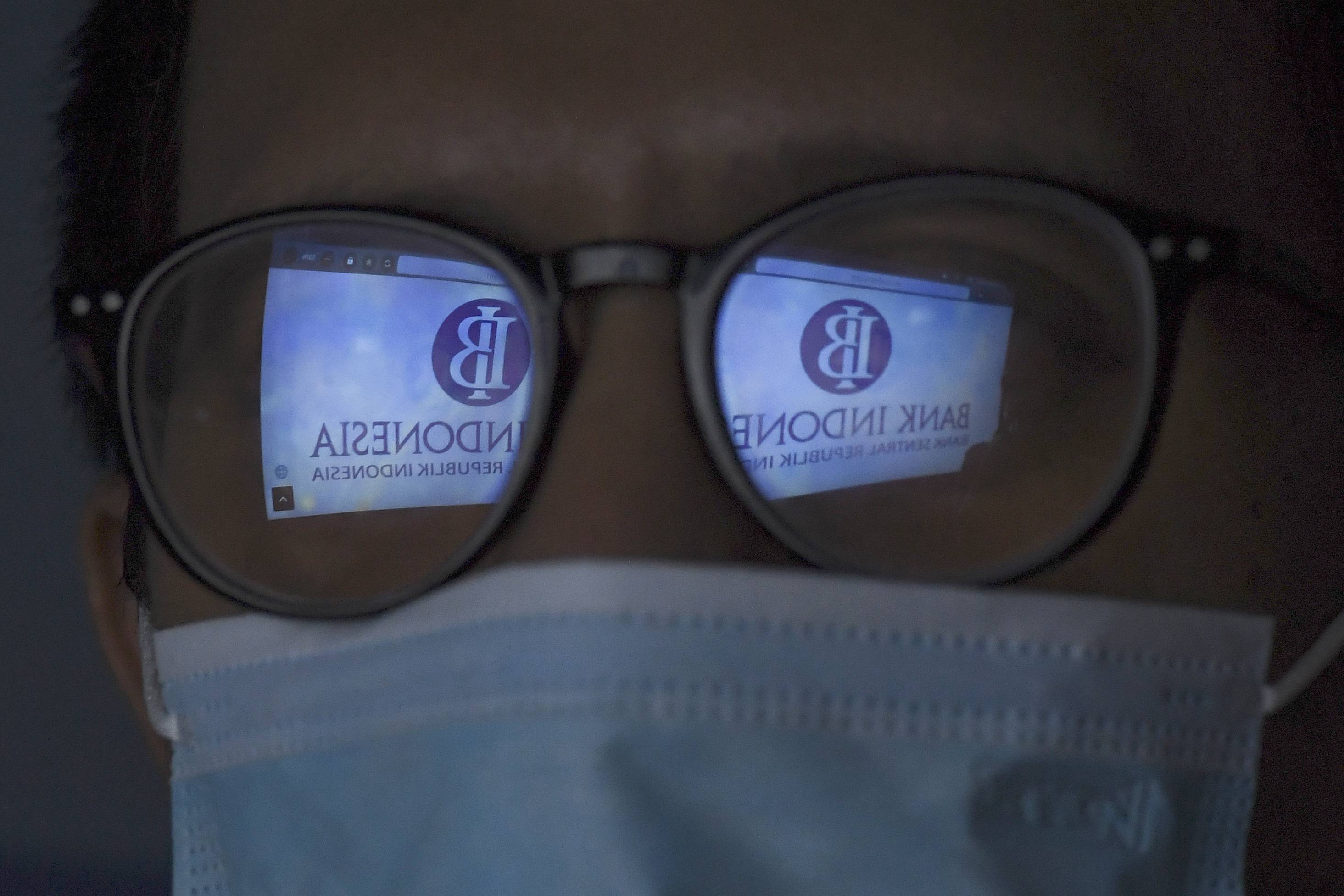 : Refleksi layar yang memampilkan logo Bank Indonesia (BI) di Jakarta, Kamis (17/6/2021).