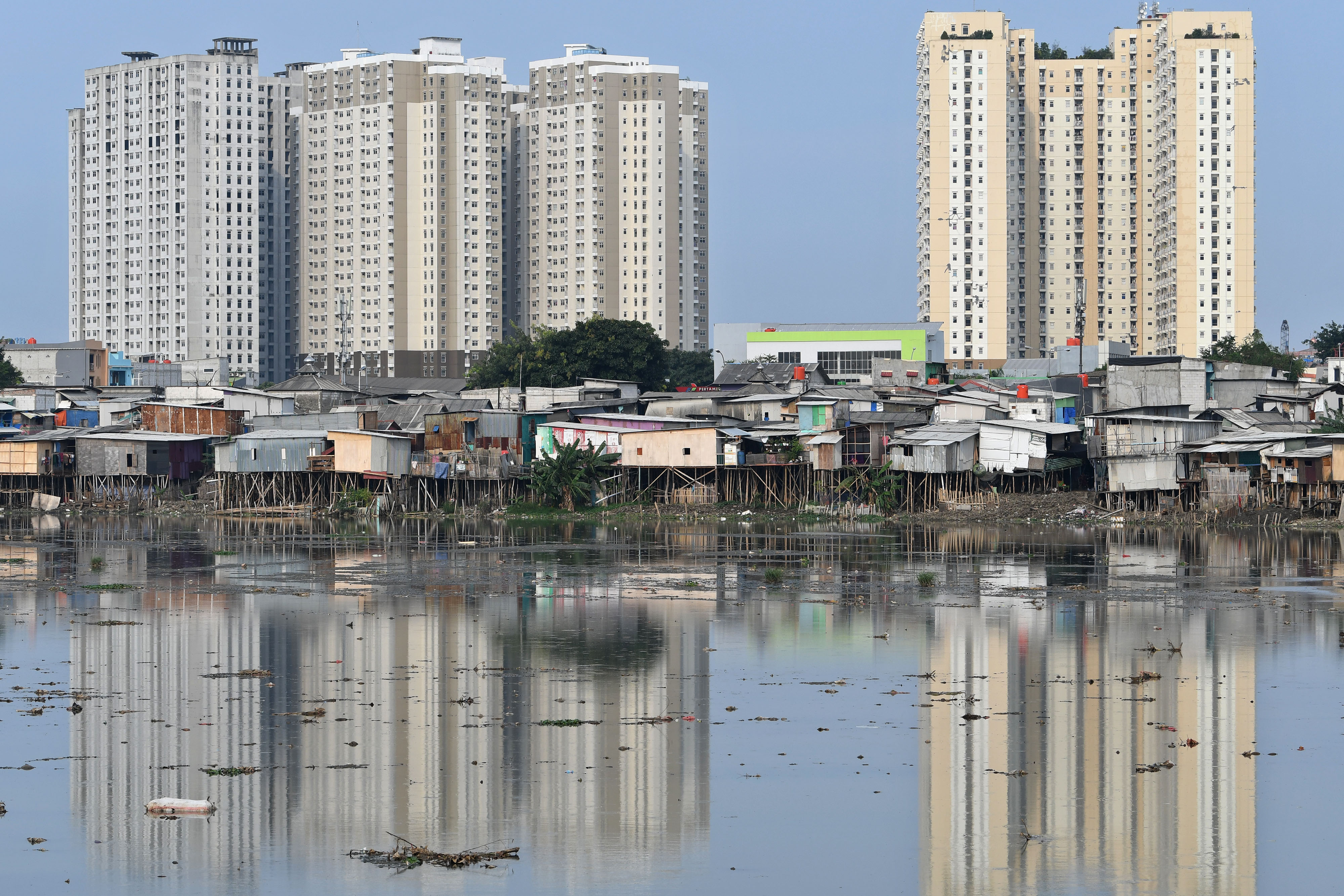 Rumah-rumah semi permanen berdiri di atas tepi Waduk Pluit, Jakarta, Jumat (14/10/2022). 
