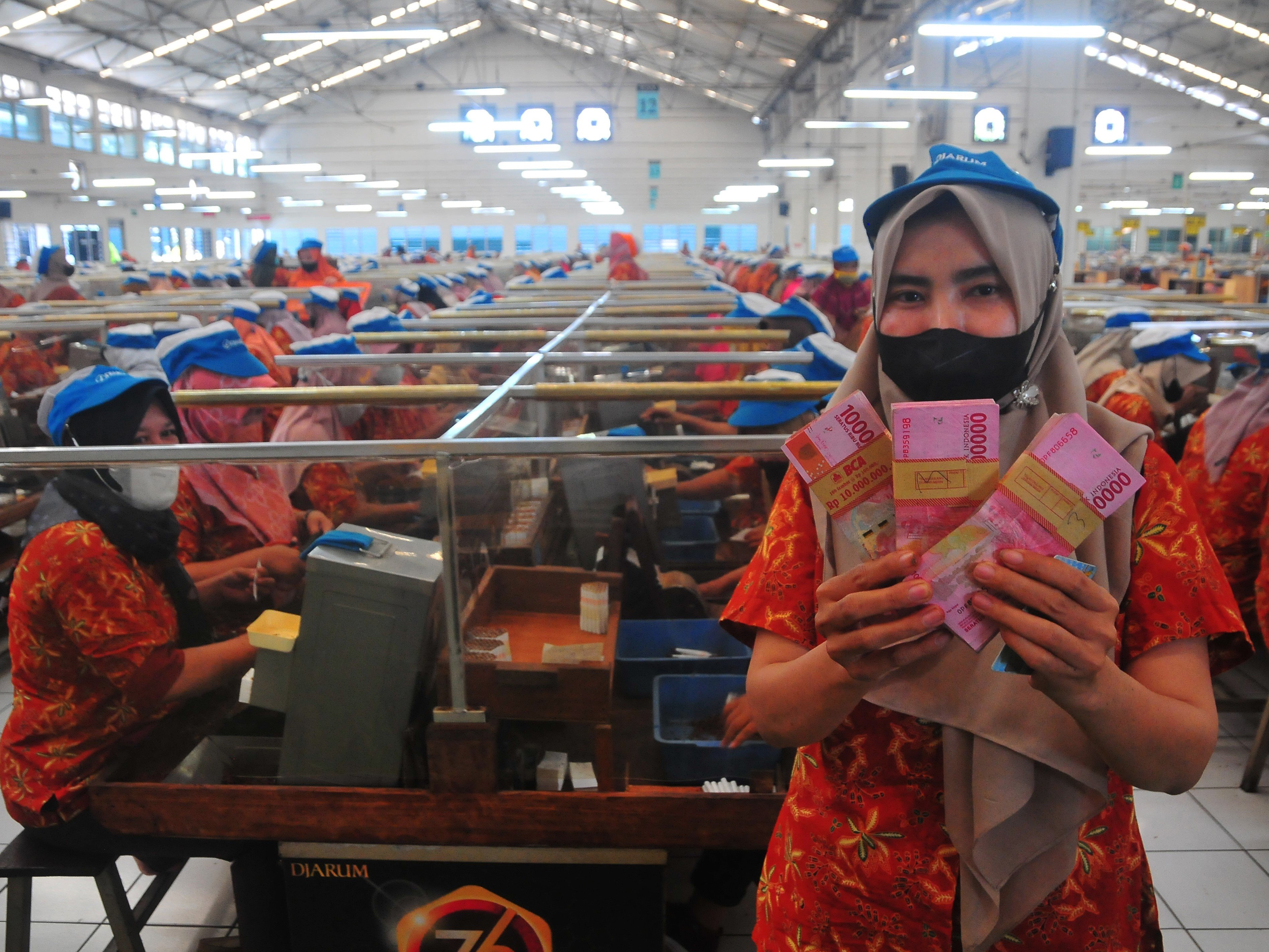 Buruh rokok menunjukkan uang bantuan langsung tunai (BLT) yang diterima saat penyaluran di salah satu pabrik rokok di Kudus, Jawa Tengah.