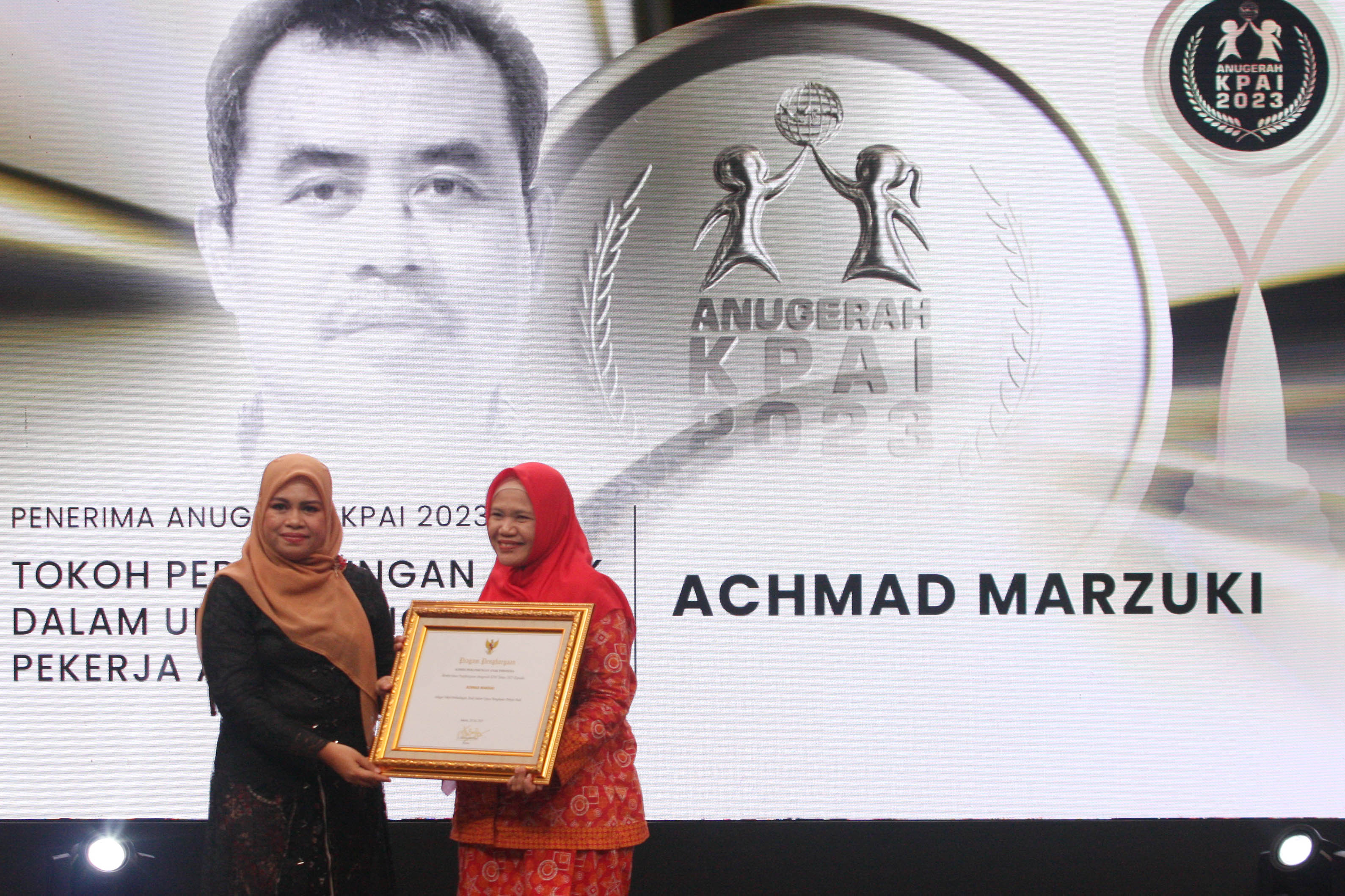 Ketua KPAI Ai Maryati Solihah (kiri) menyerahkan Anugerah KPAI 2023 kepada perwakilan keluarga Achmad Marzuki, Kamis (20/7).