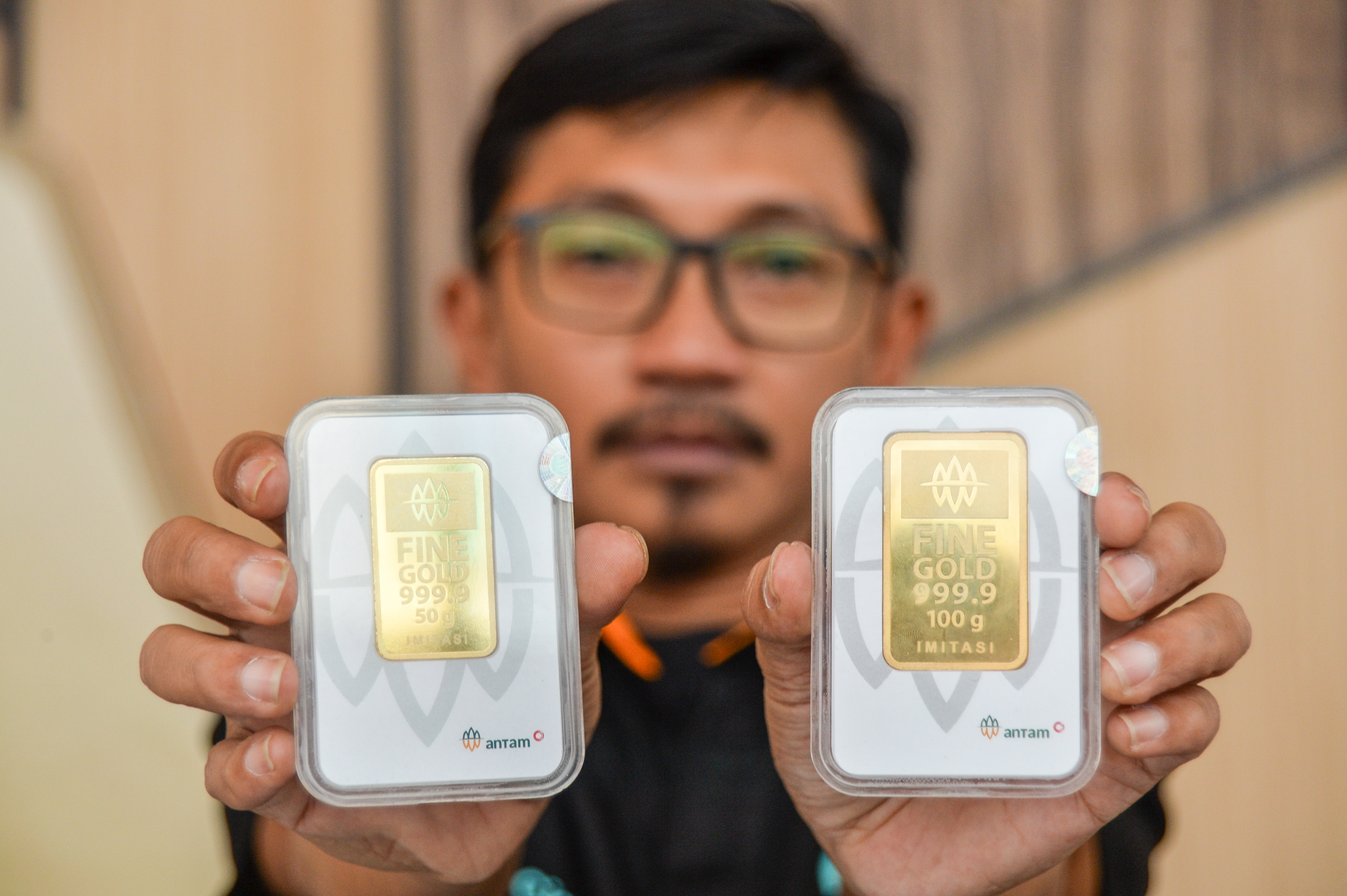 Pekerja menunjukkan emas batangan yang dipamerkan pada pameran investasi tanpa cemas dengan emas di Bandung, Jawa Barat, Rabu (26/10/2022).