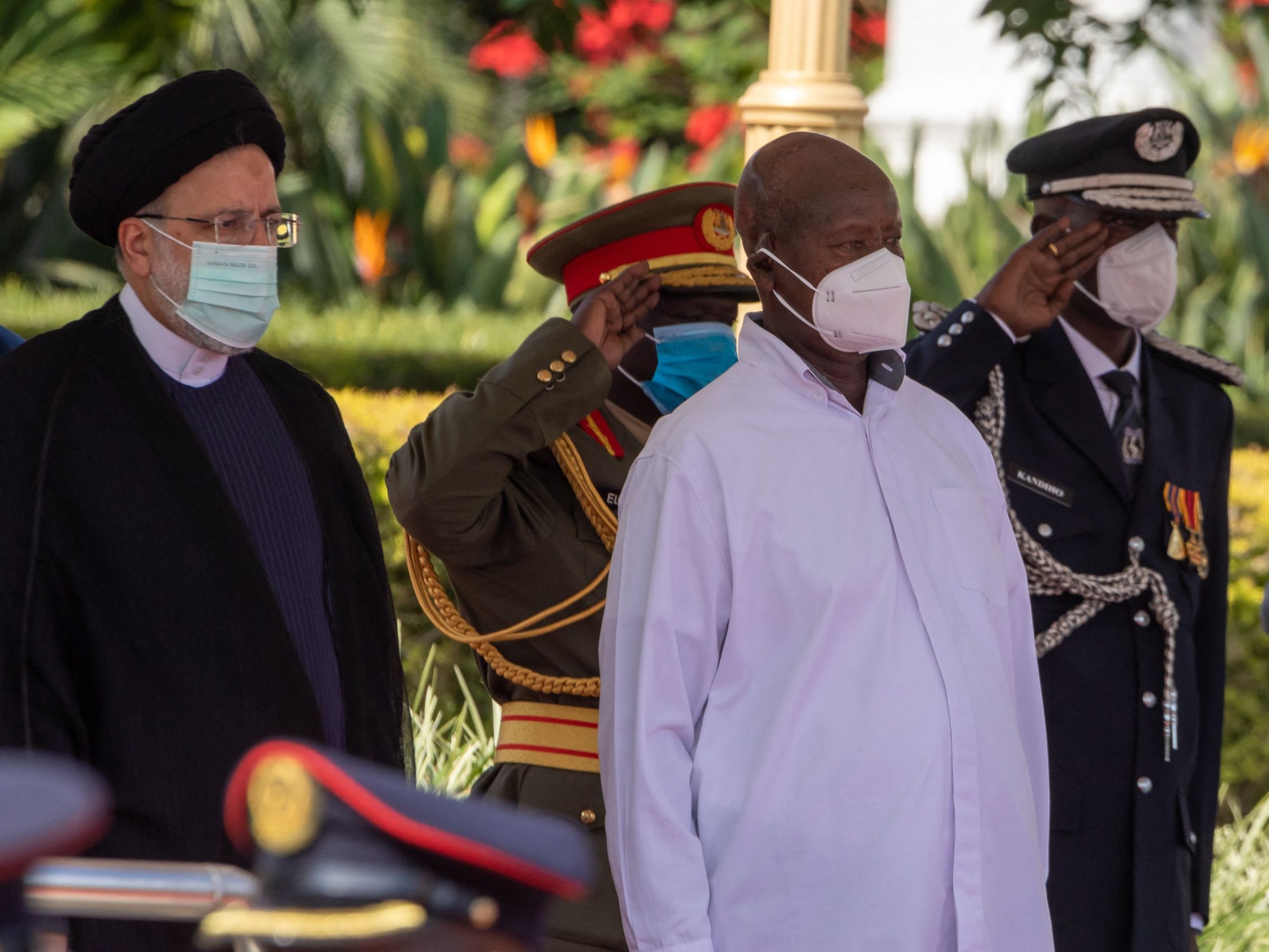 Presiden Iran Ebrahim Raisi (kiri) dan Presiden Uganda Yoweri Museveni (ketiga kiri) menyanyikan lagu kebangsaan mereka saat kunjungan.