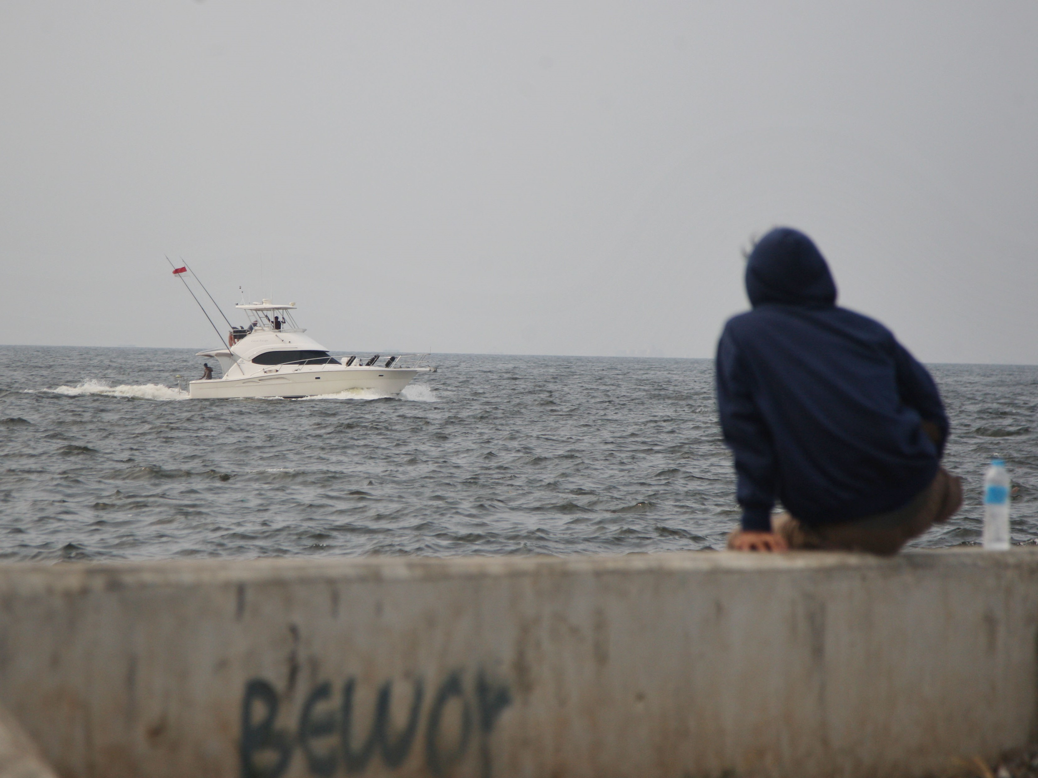 Warga duduk di atas tanggul laut Muara Baru, Jakarta Utara, Rabu (24/05/2023).