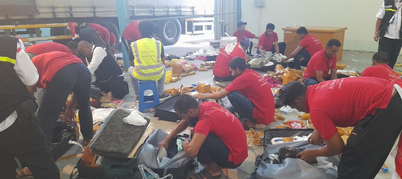 Koper-koper jemaah haji dibongkar untuk mengeluarkan air zamzam yang terdeteksi oleh pemeriksaa  x-ray.