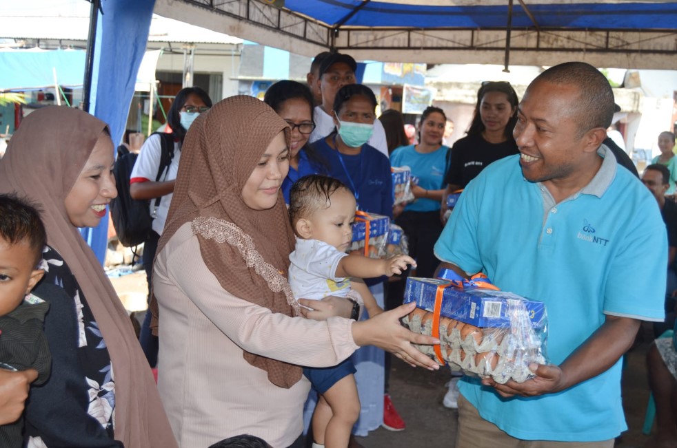 Wakil Bank NTT Cabang Larantuka, Hans Utama A Mbete menyerahkan paket makanan stunting kepada warga Larantuka.