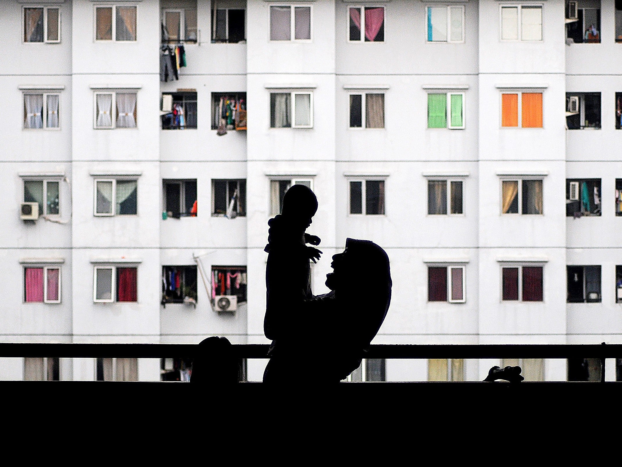Siluet seorang ibu bermain bersama anaknya di Rumah Susun Sewa Pulogebang, Jakarta Timur.
