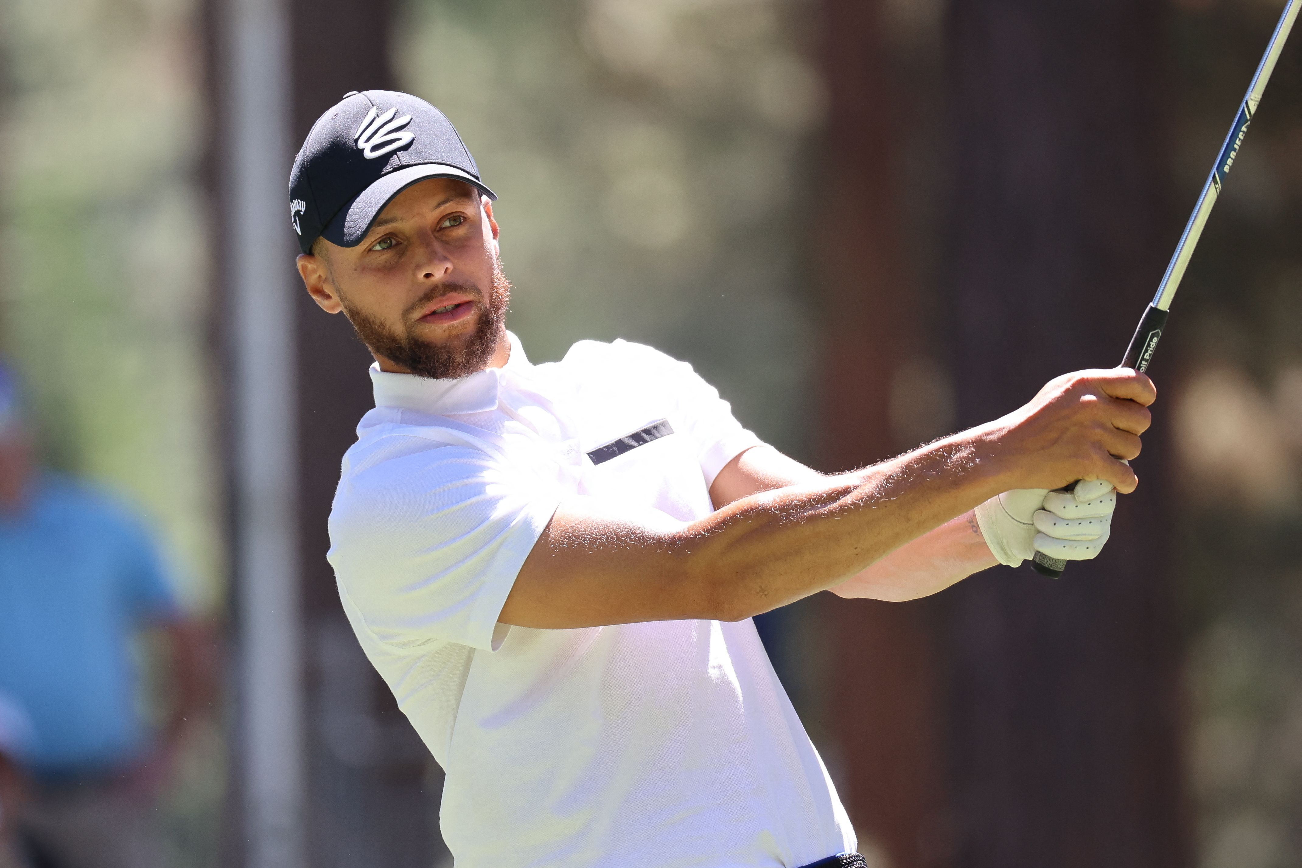 Bintang klub NBA, Golden State Warriors, Stephen Curry bermain golf.