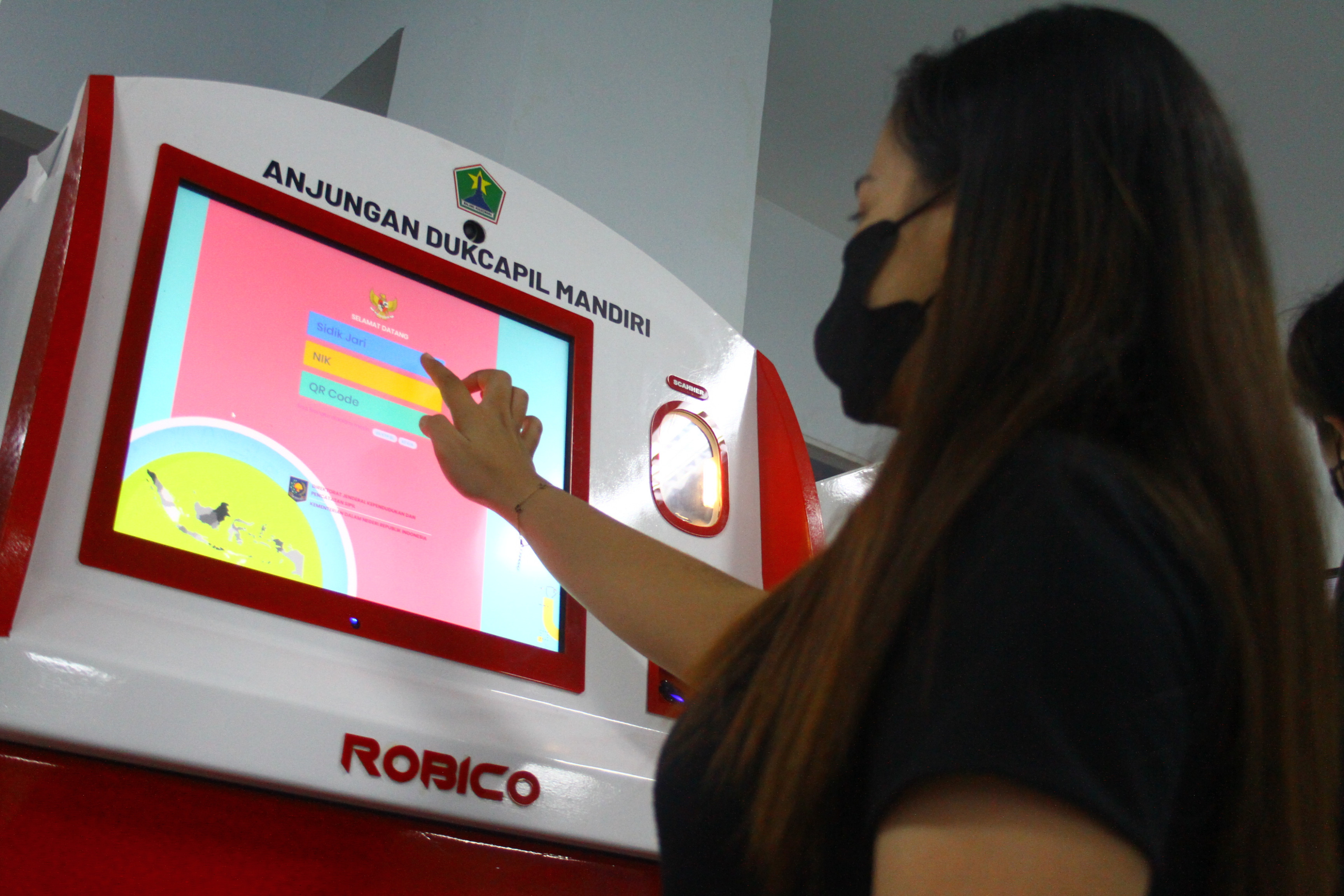  Warga mencetak dokumen kependudukan menggunakan mesin Anjungan Dukcapil Mandiri 