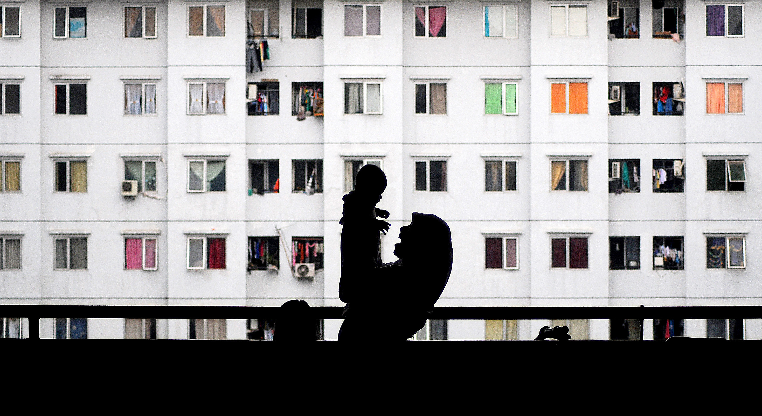 Siluet seorang ibu bermain bersama anaknya di Rumah Susun Sewa Pulogebang, Jakarta Timur