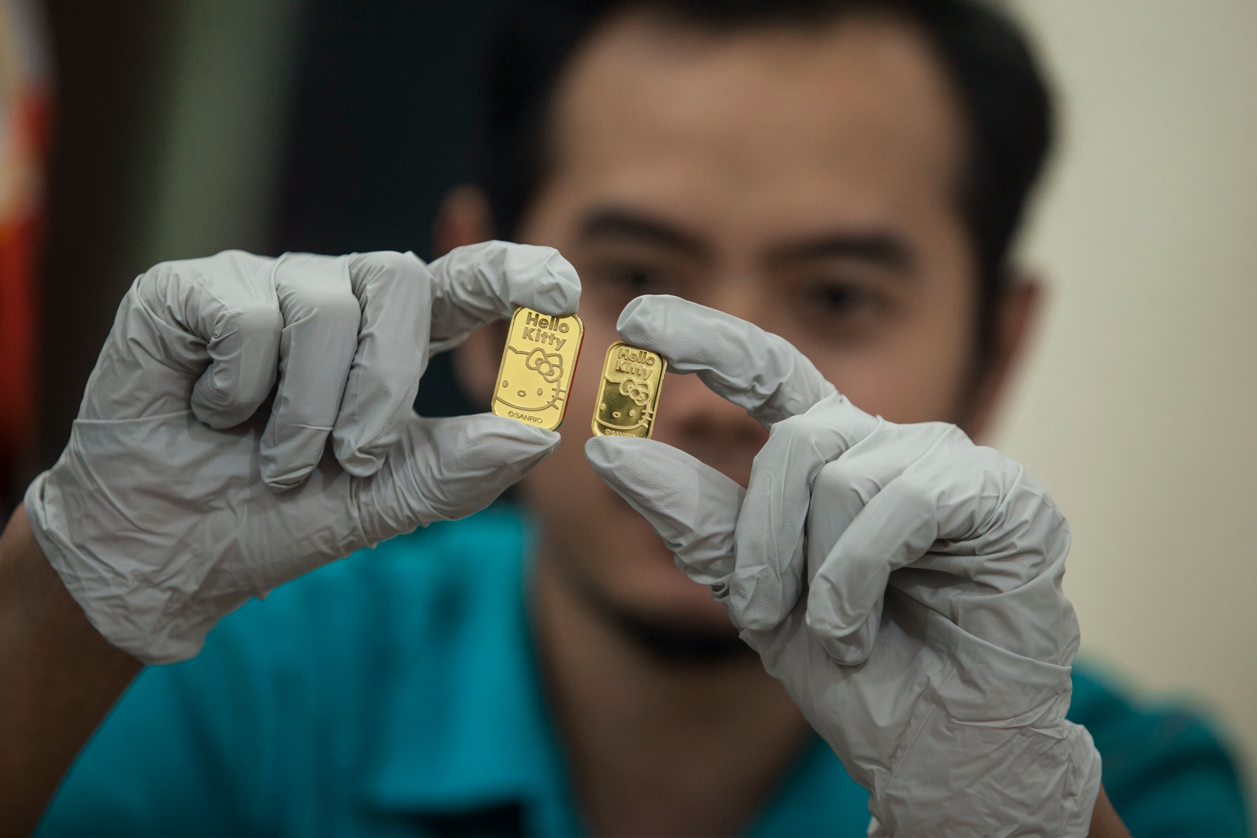 Petugas menunjukkan produk emas motif Hello Kitty.