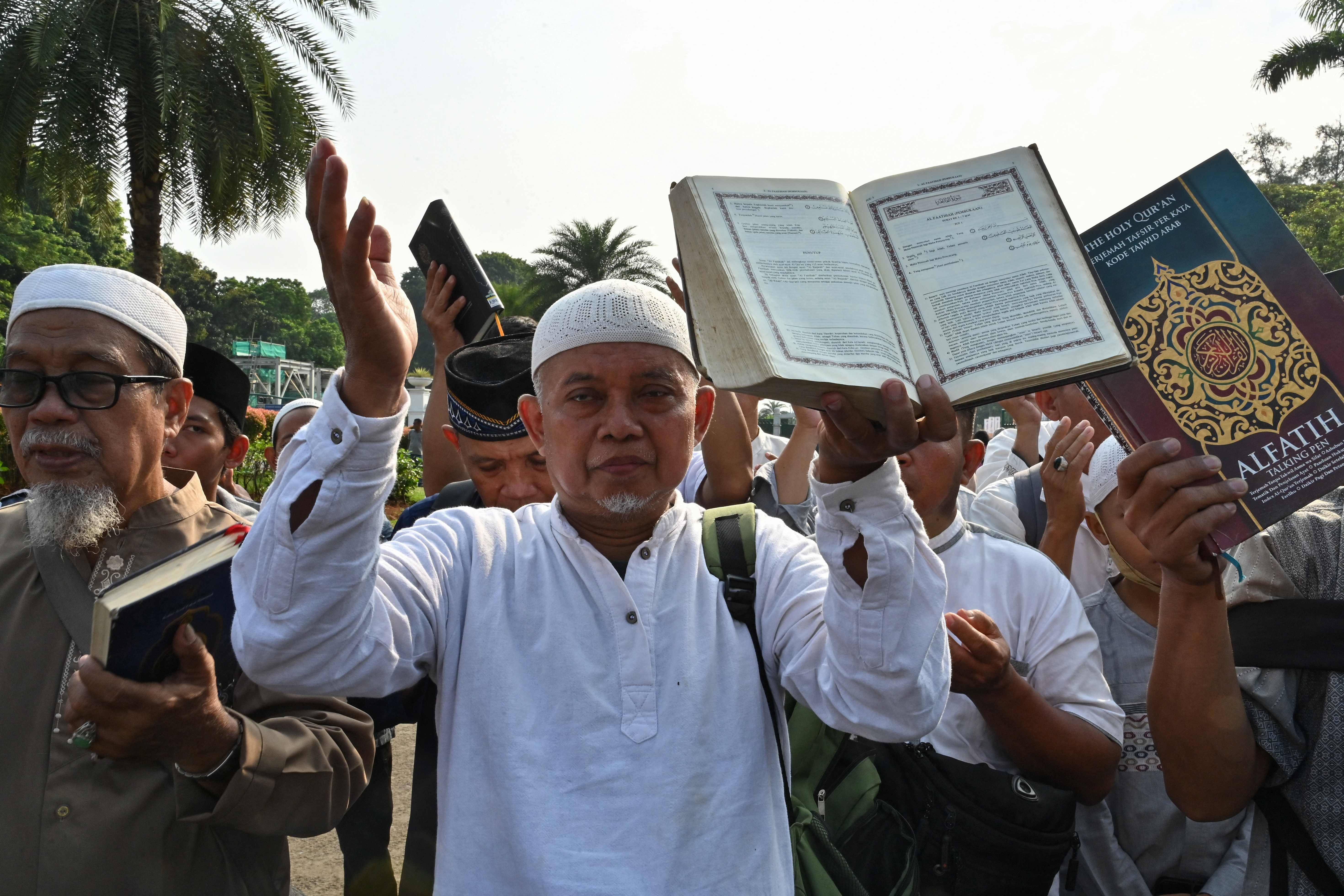 Demonstran di Jakarta membawa Al-Qur'an saat memprotes aksi pembakaran kitab suci itu di Stockholm, Swedia.