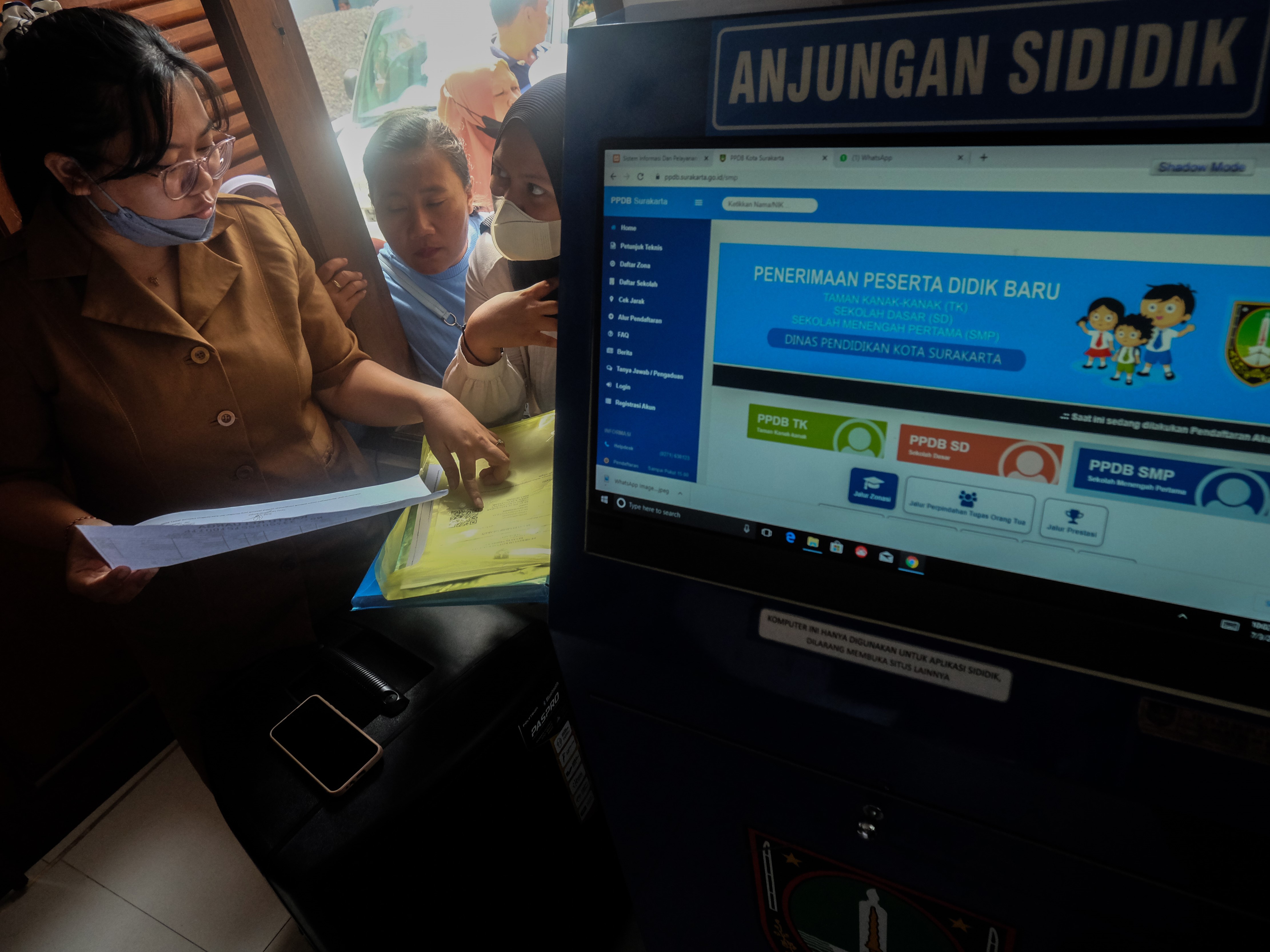 Pegawai melayani wali calon peserta didik baru yang mengantre untuk konsultasi PPDB jalur zonasi di kantor Dinas Pendidikan Kota Solo.