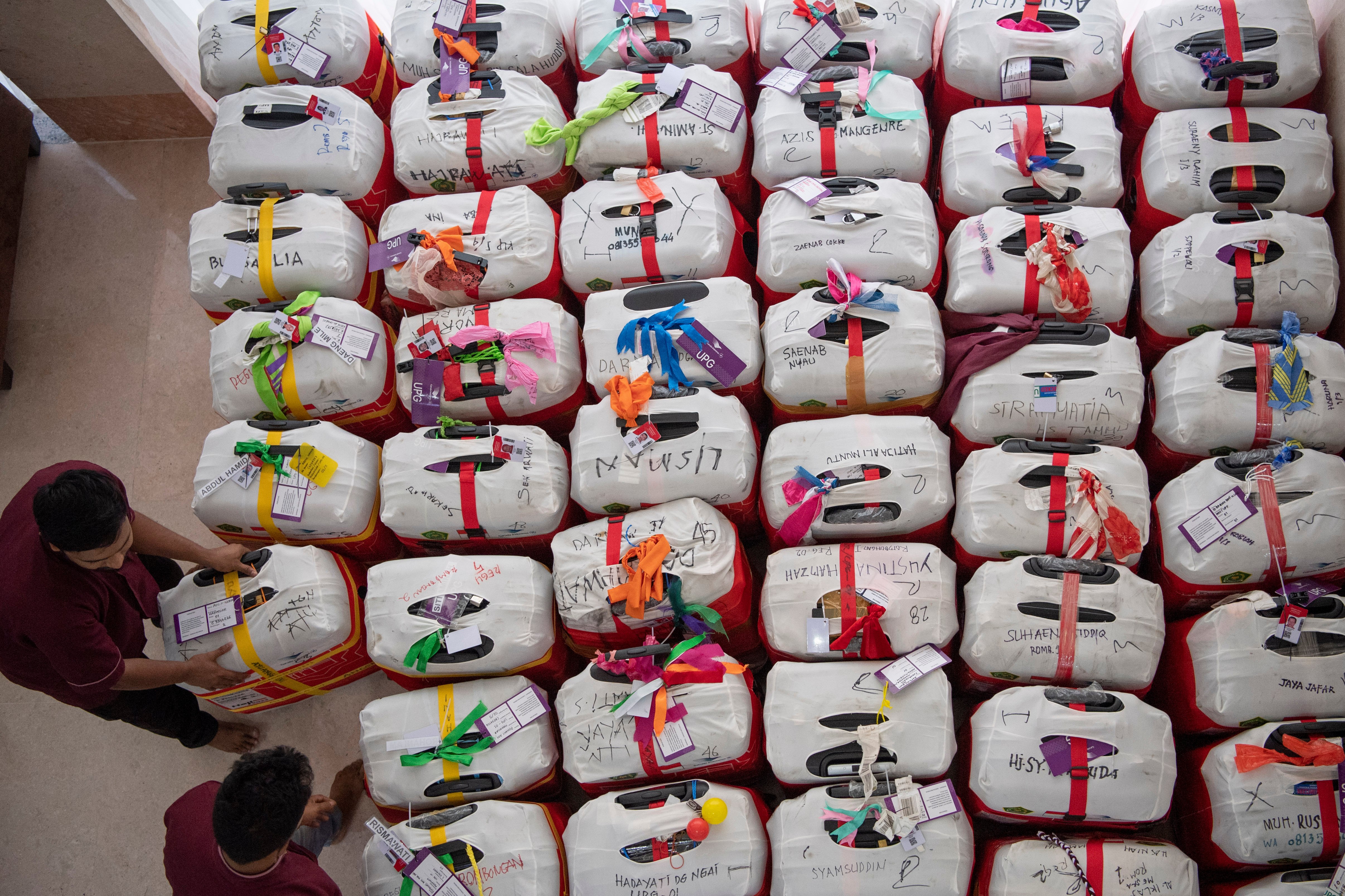 Dua petugas menata koper jamaah haji Indonesia kloter UPG 1 yang akan pulang ke Tanah Air