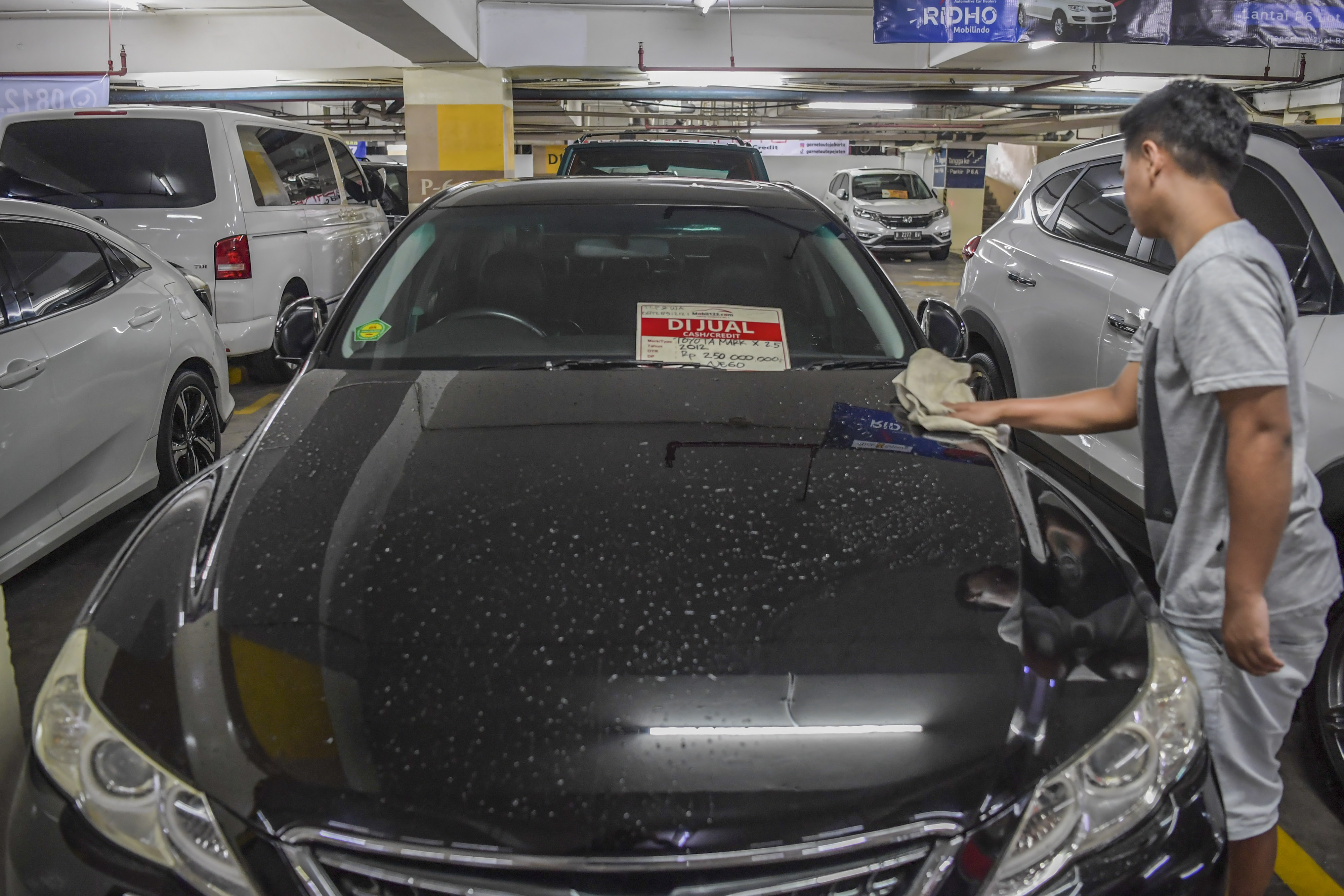 ilustrasi: Petugas showroom membersihkan mobil bekas yang hendak dijual