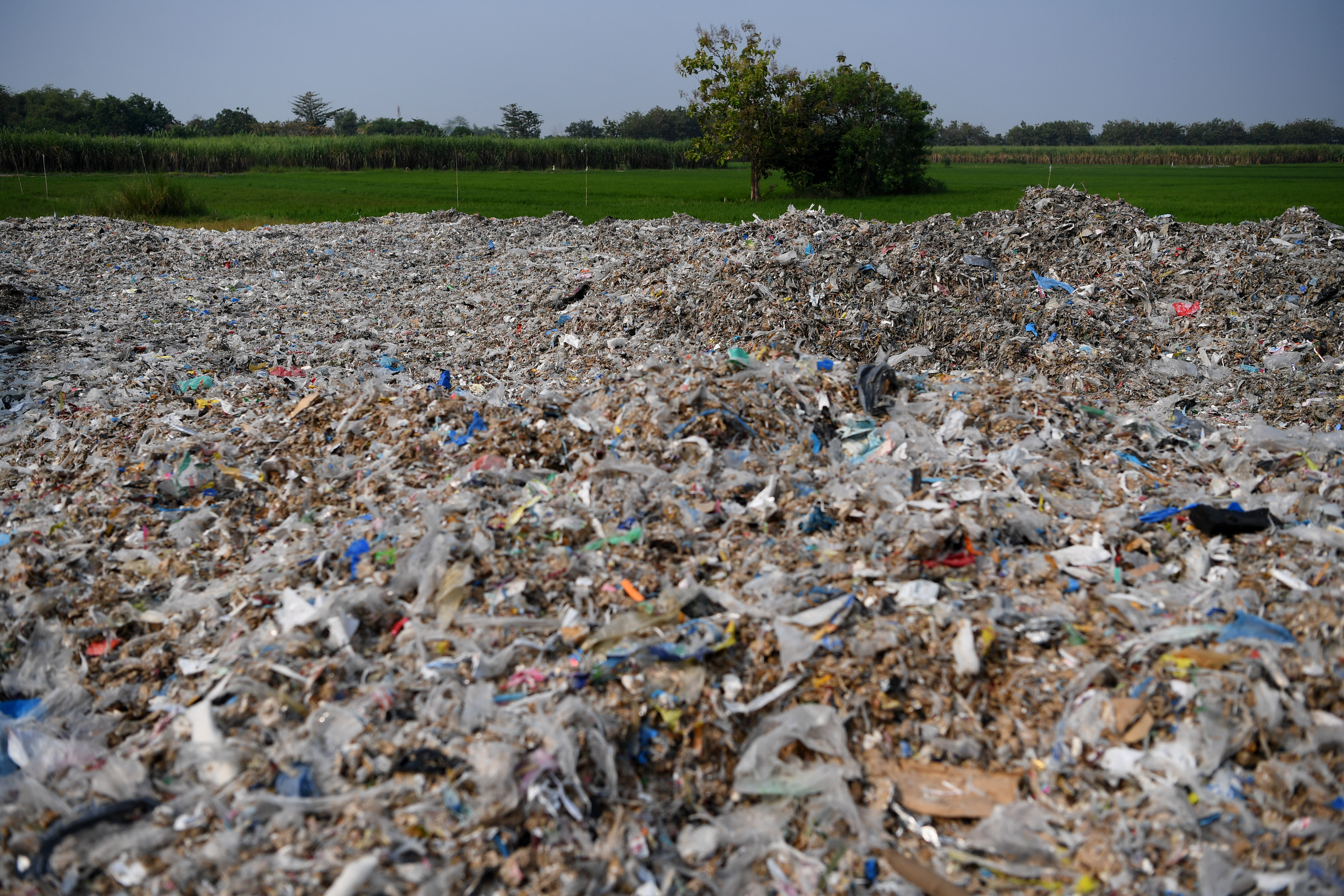 Tumpukan sampah plastik impor berada di sekitar pemukiman warga di Desa Bangun di Mojokerto, Jawa Timur, tahun 2019.