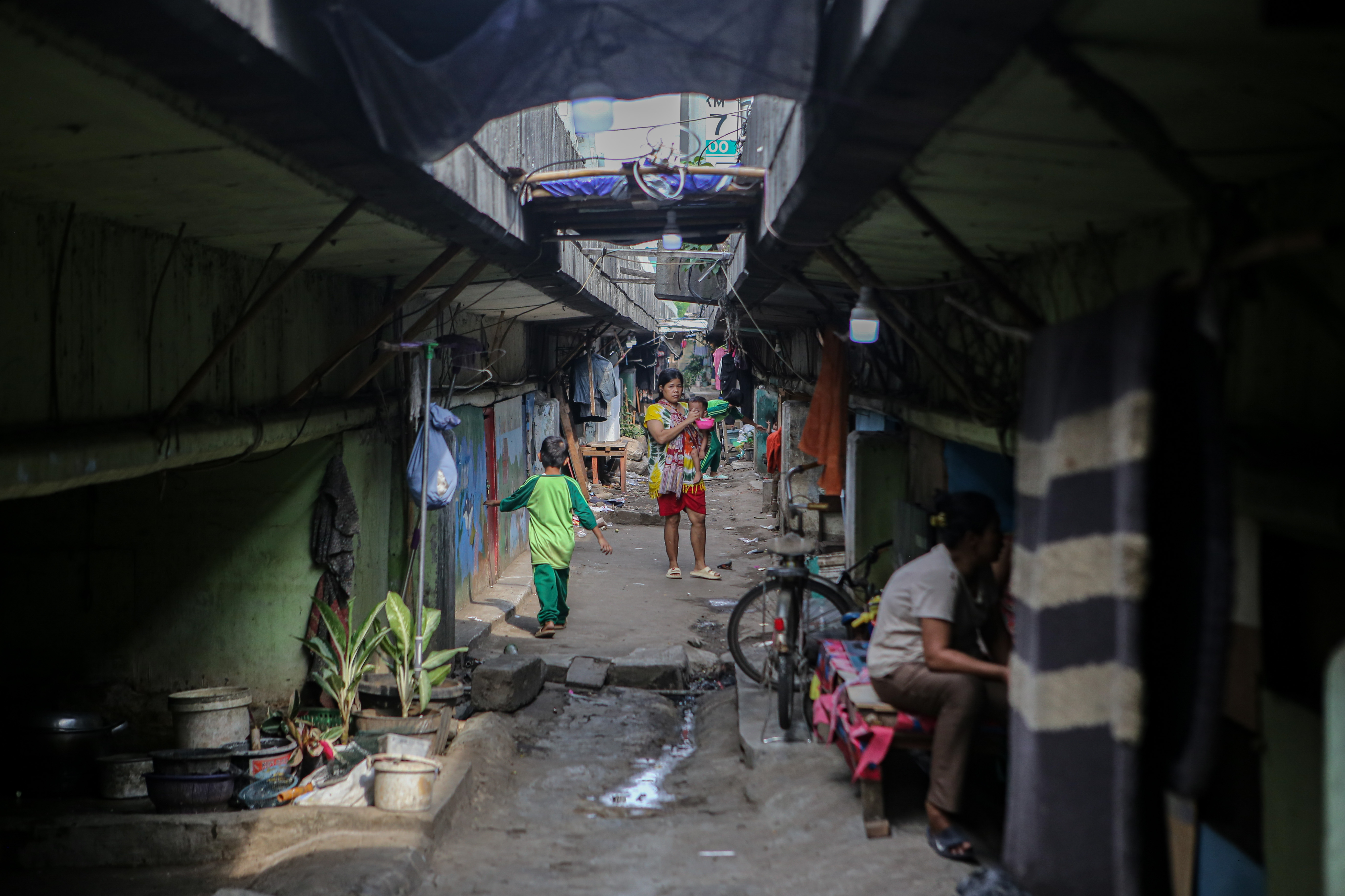 Sejumlah warga di permukiman di bawah jalan tol dalam kota Cawang-Tomang-Pluit di Jelambar Baru, Jakarta, Selasa (20/6).